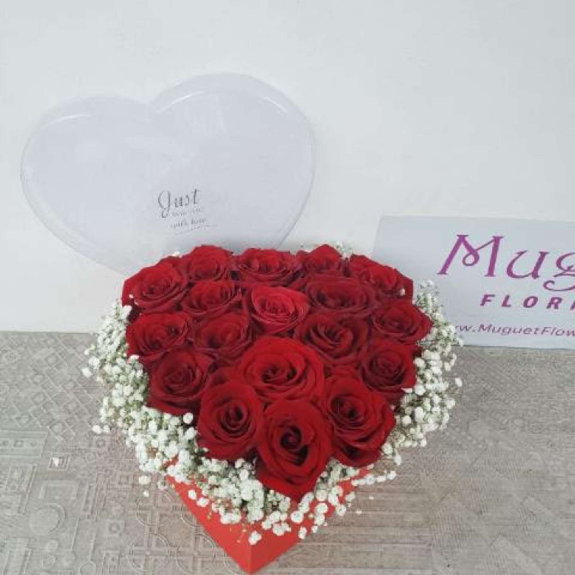 Heart-shaped box of red roses with white baby's breath and clear heart balloons