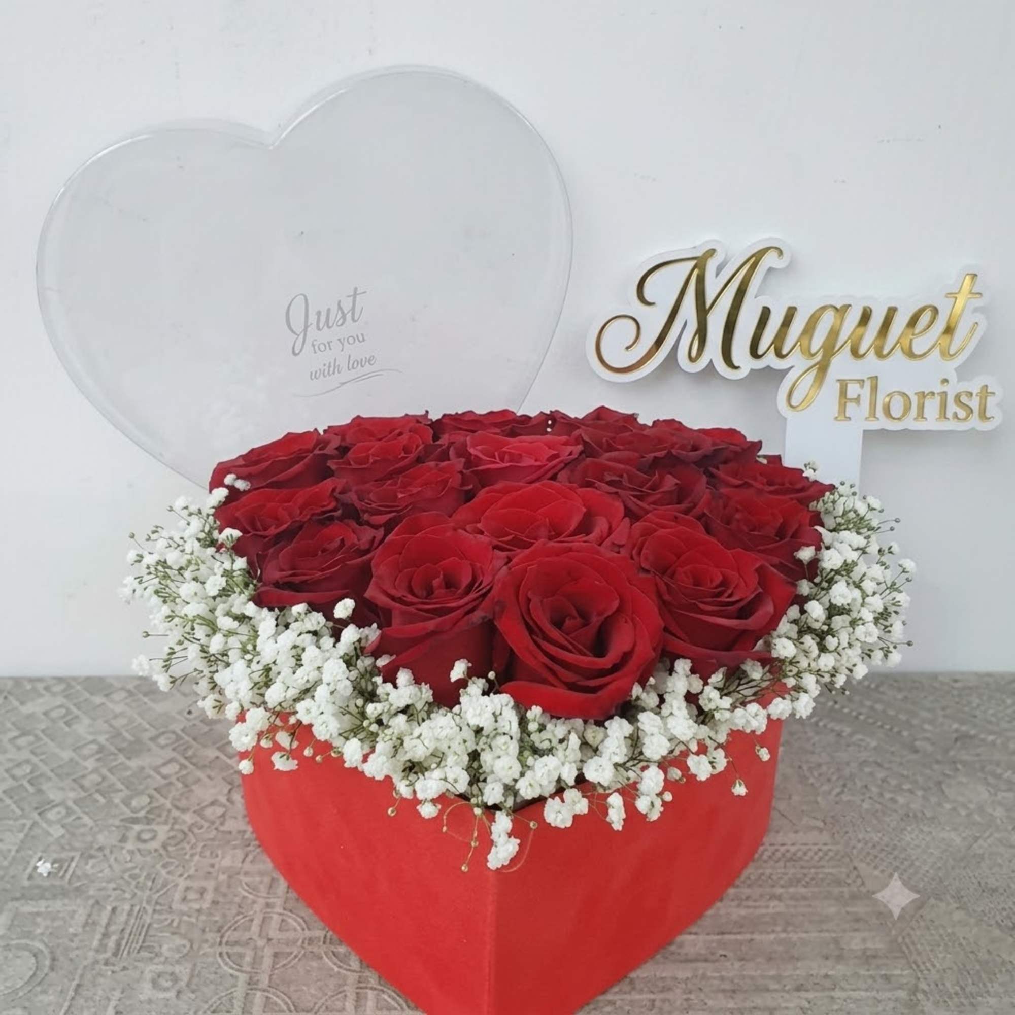 Heart-shaped box of red roses with white baby's breath