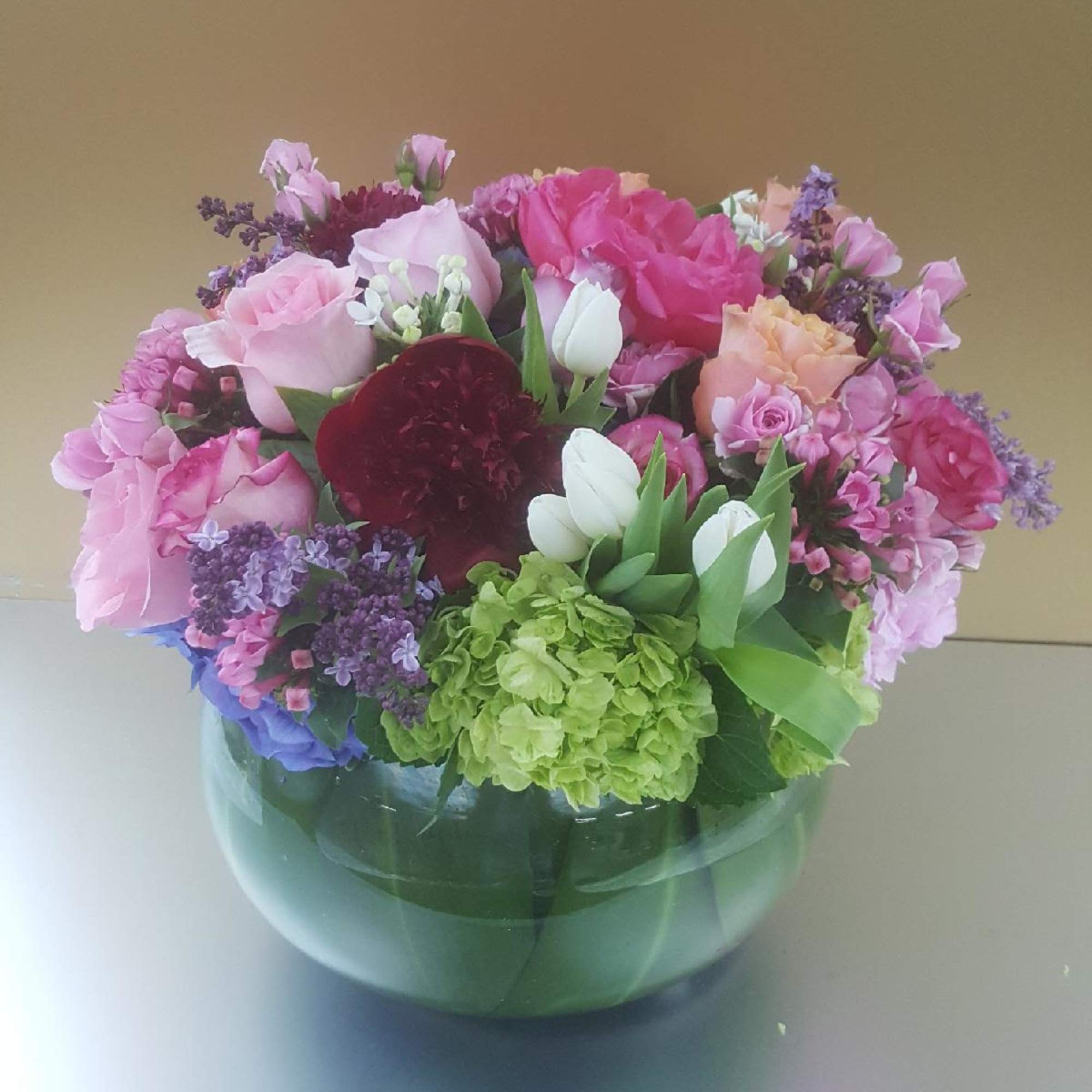 Mixed pink and purple bouquet in a round glass vase
