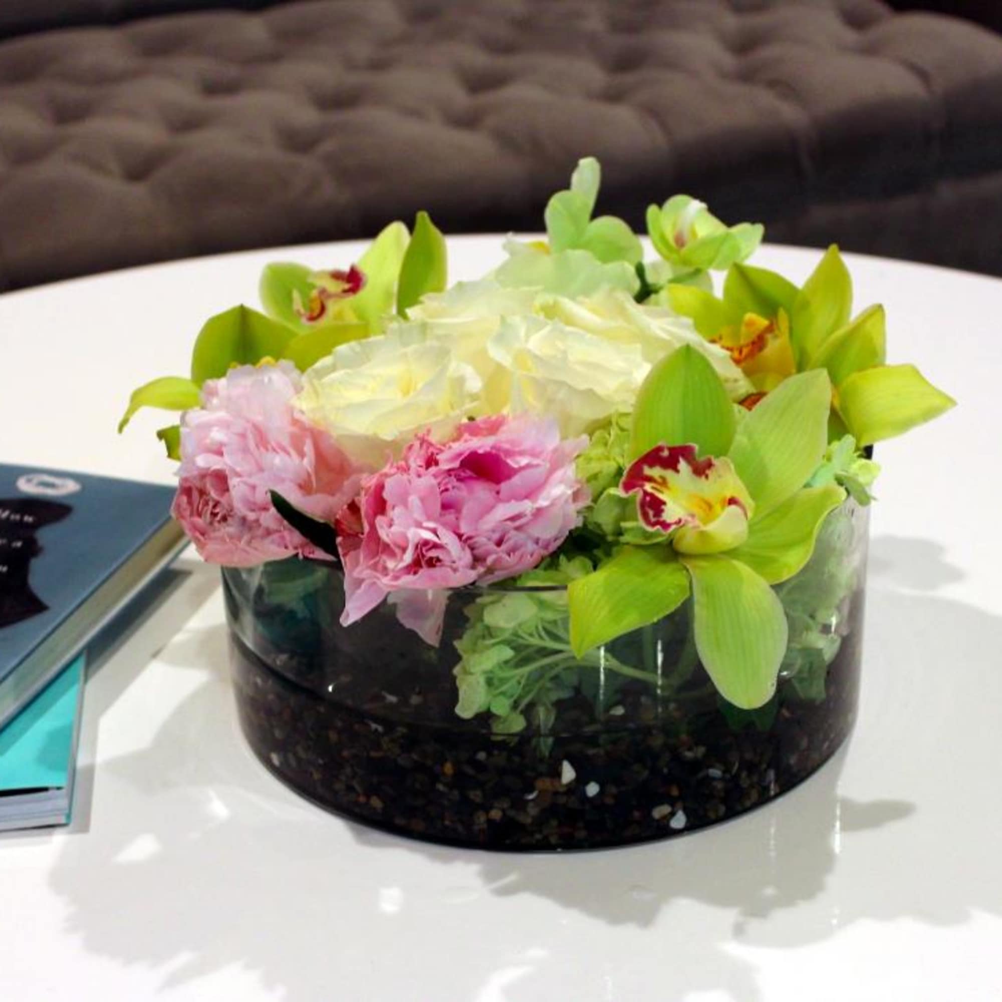 Pink and white flowers arranged in a low glass bowl