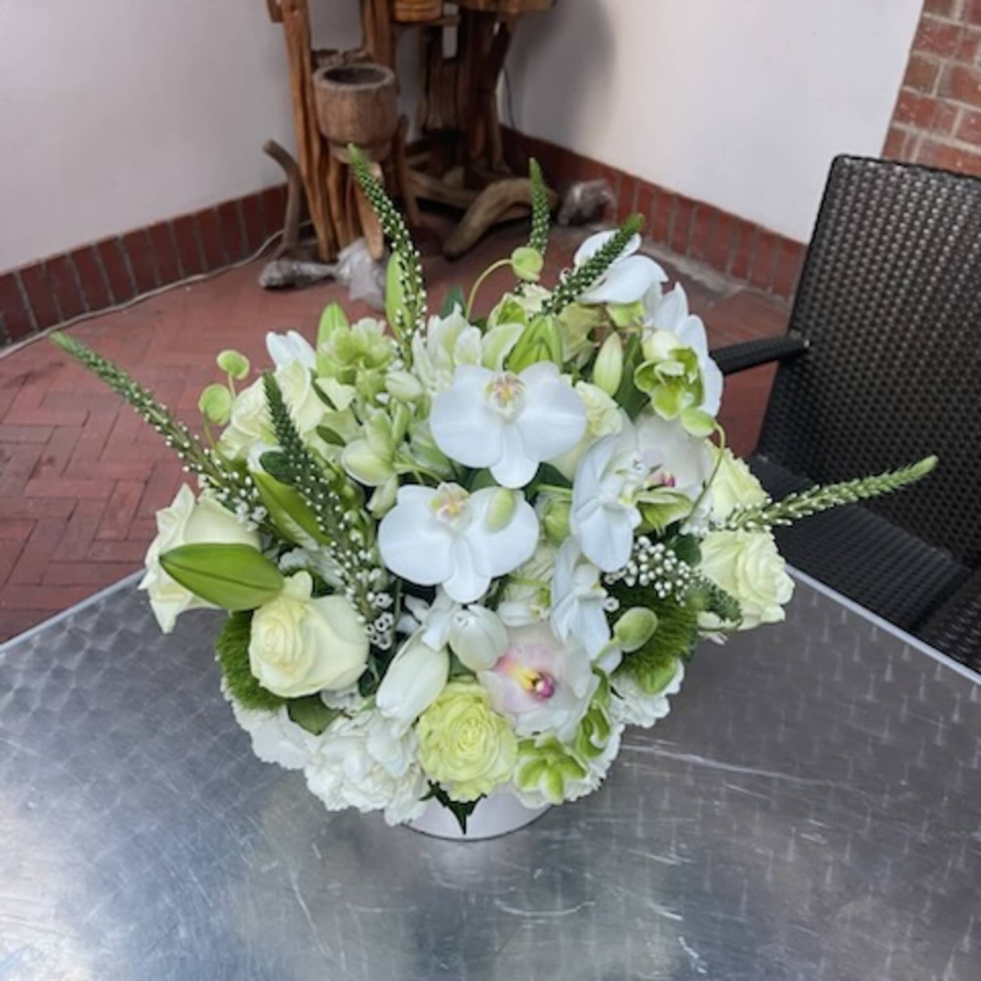 White floral arrangement in a low round container