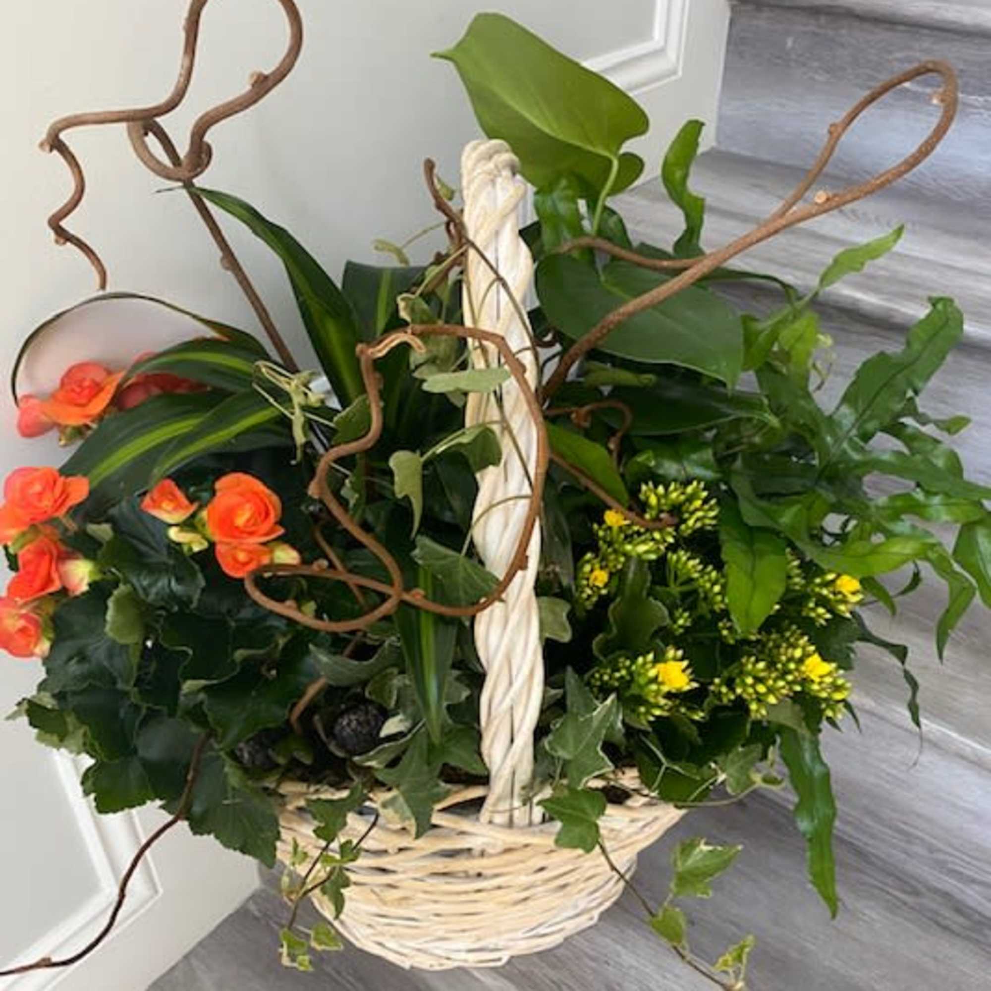 Basket arrangement with orange roses and yellow flowers
