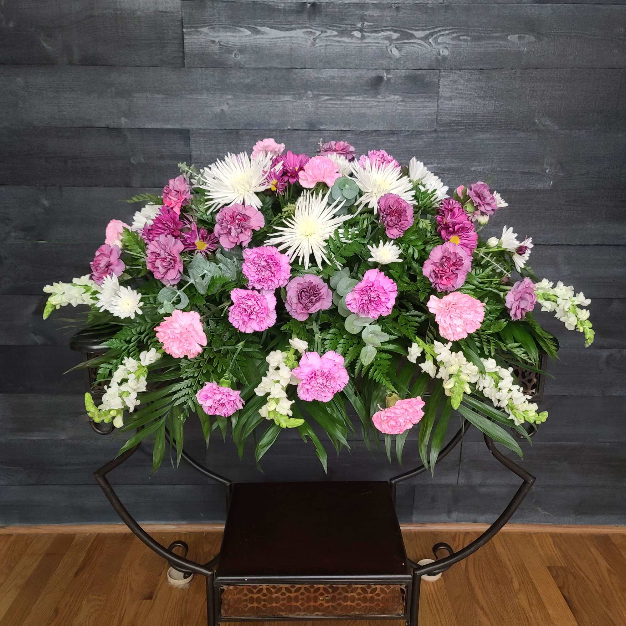 Large pink and white floral arrangement on a stand
