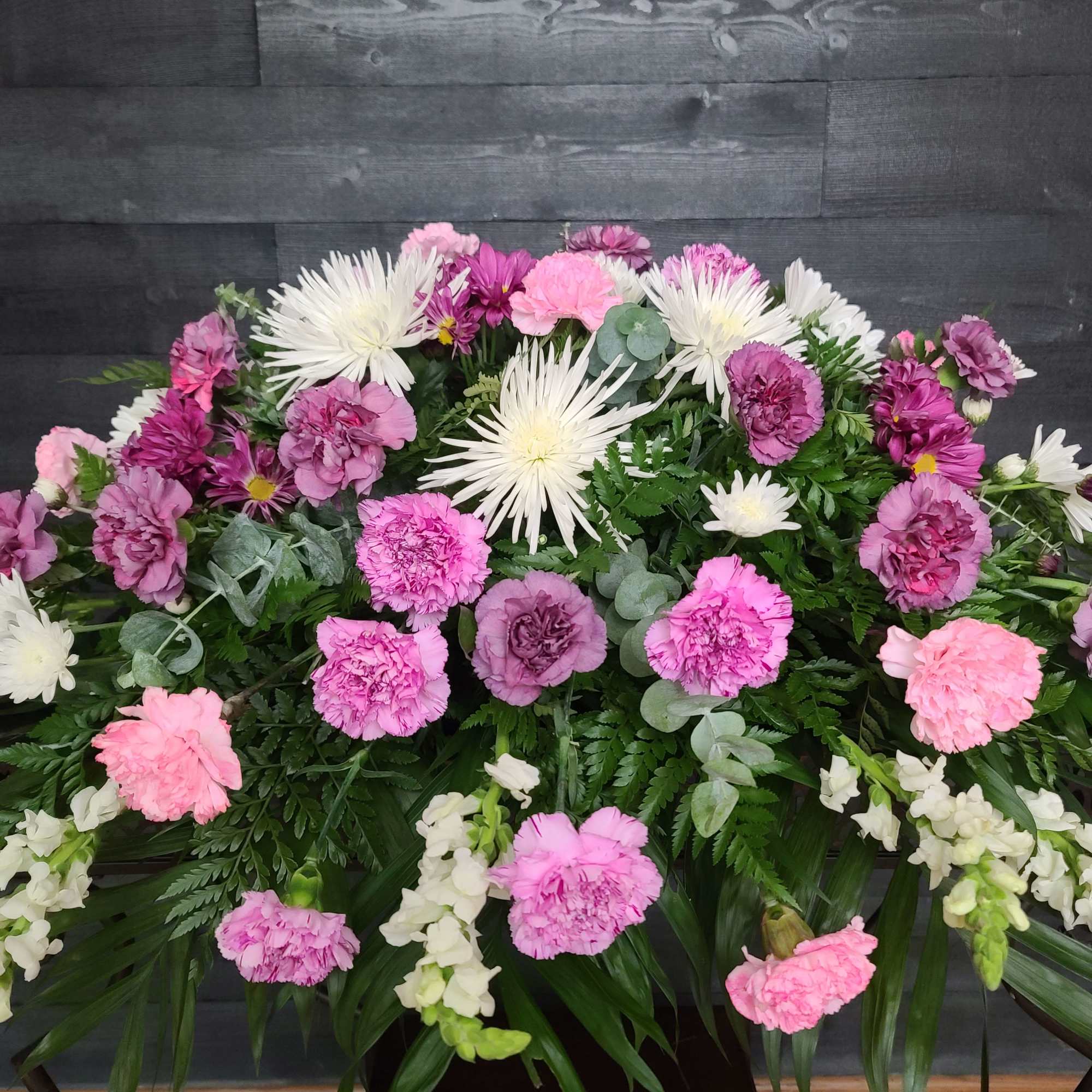 Pink and white floral arrangement with carnations and white spider mums