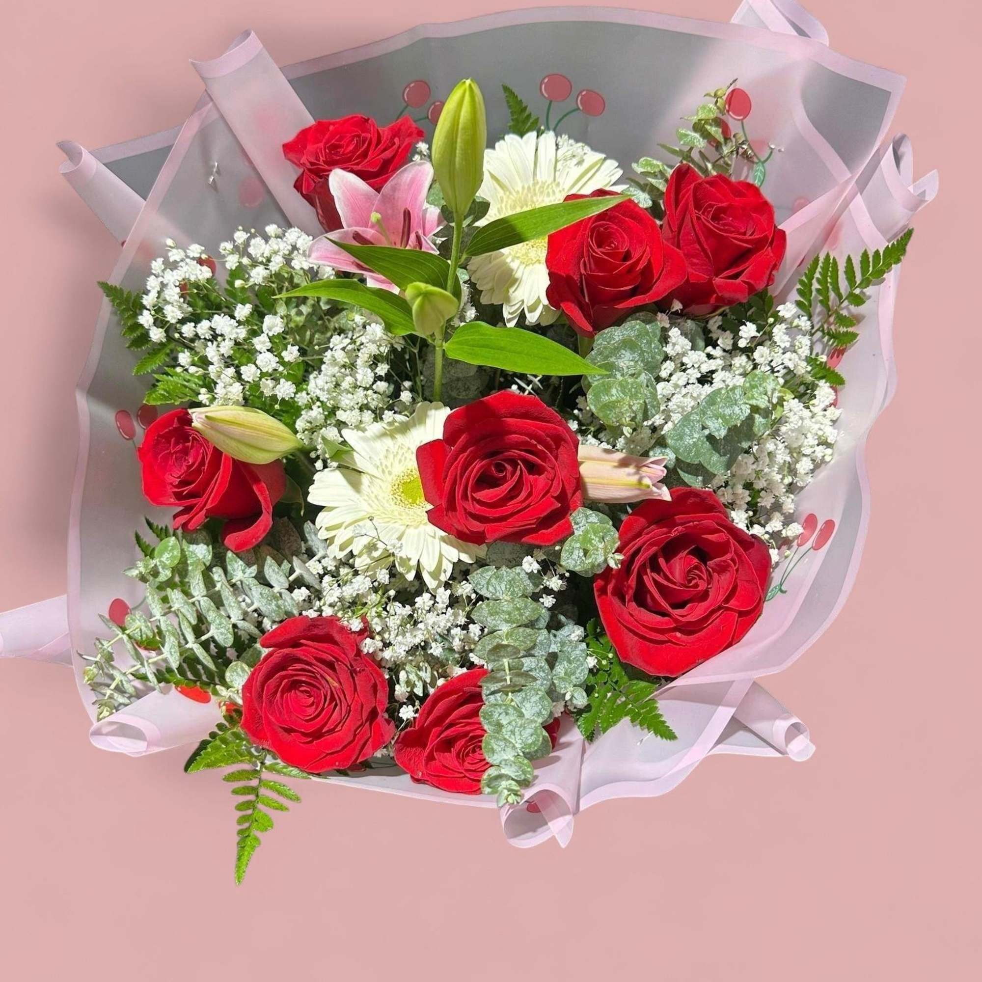 Bouquet of red roses and white flowers wrapped in pink paper