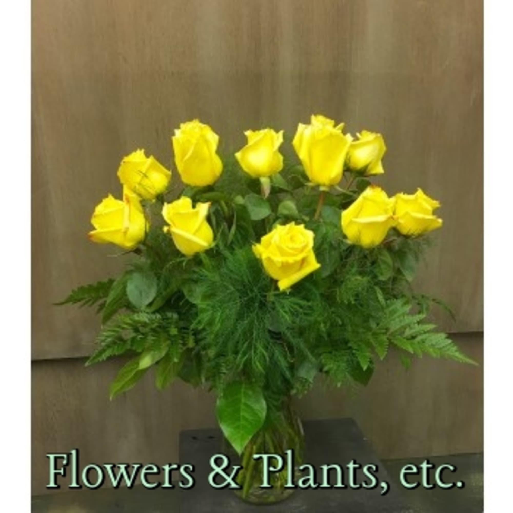 Bouquet of yellow roses with greenery in a clear vase
