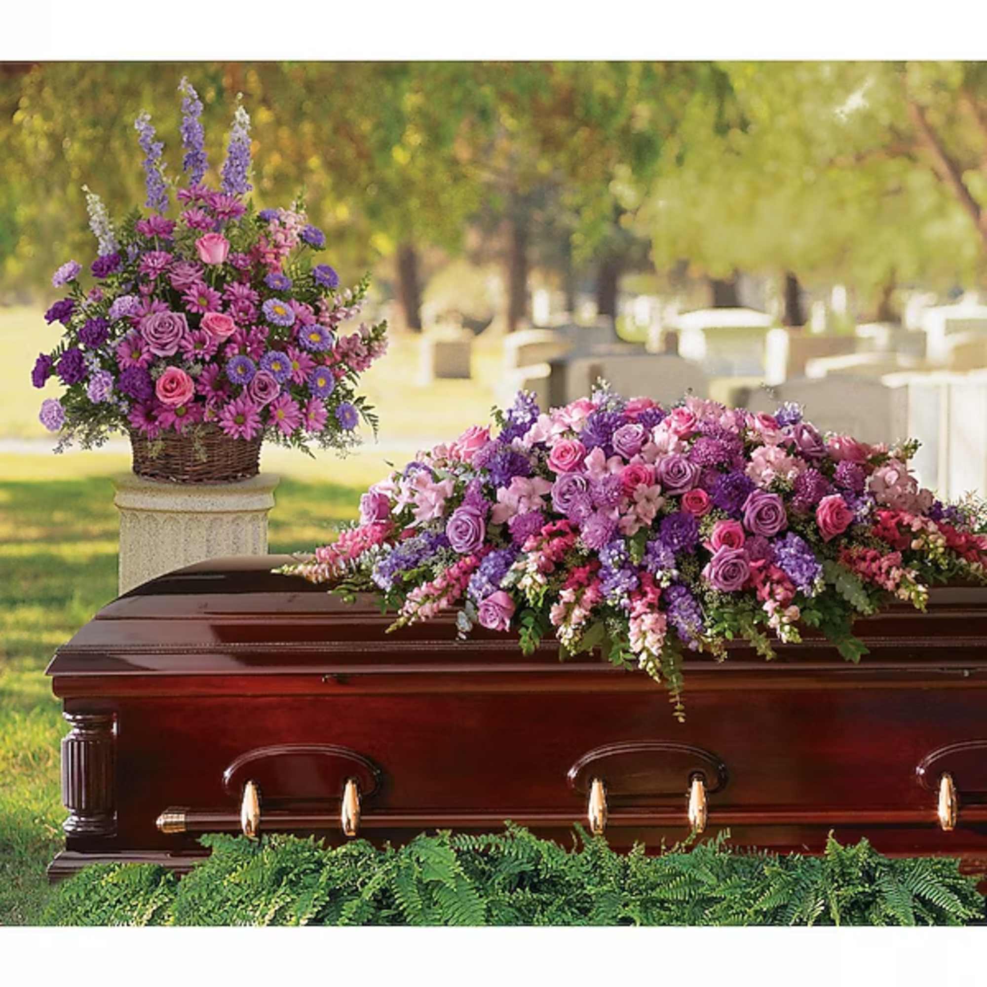 Purple and pink floral casket spray with a matching basket arrangement