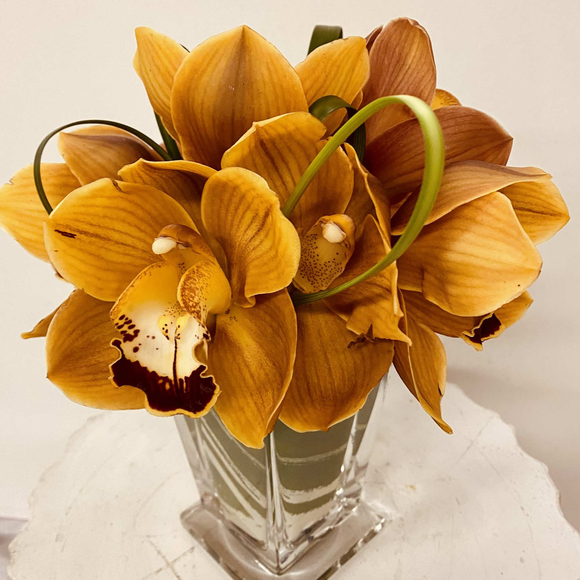 Orange orchid bouquet in a clear glass vase