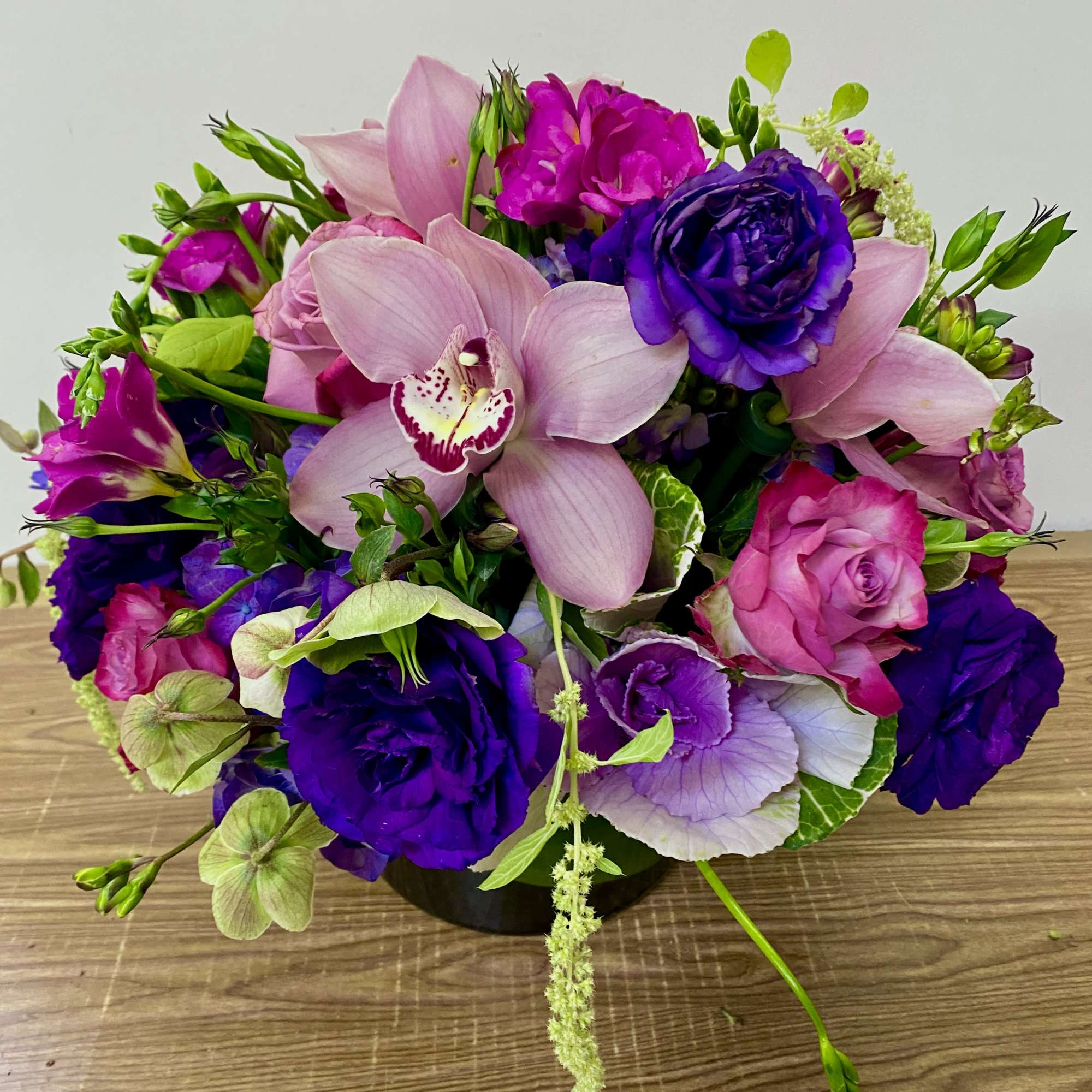 Pink and purple mixed bouquet in a low black container