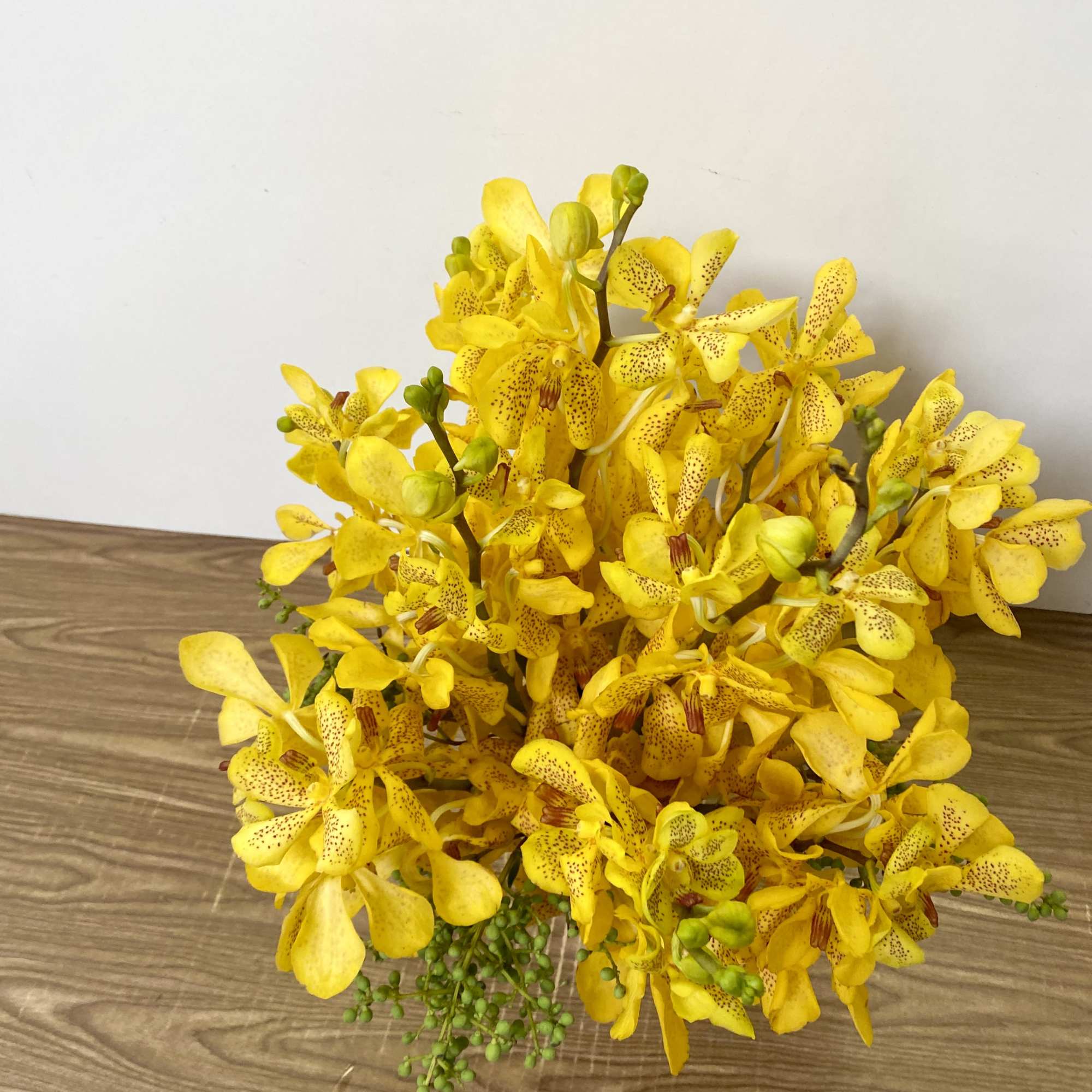 Yellow orchid bouquet on a wooden surface