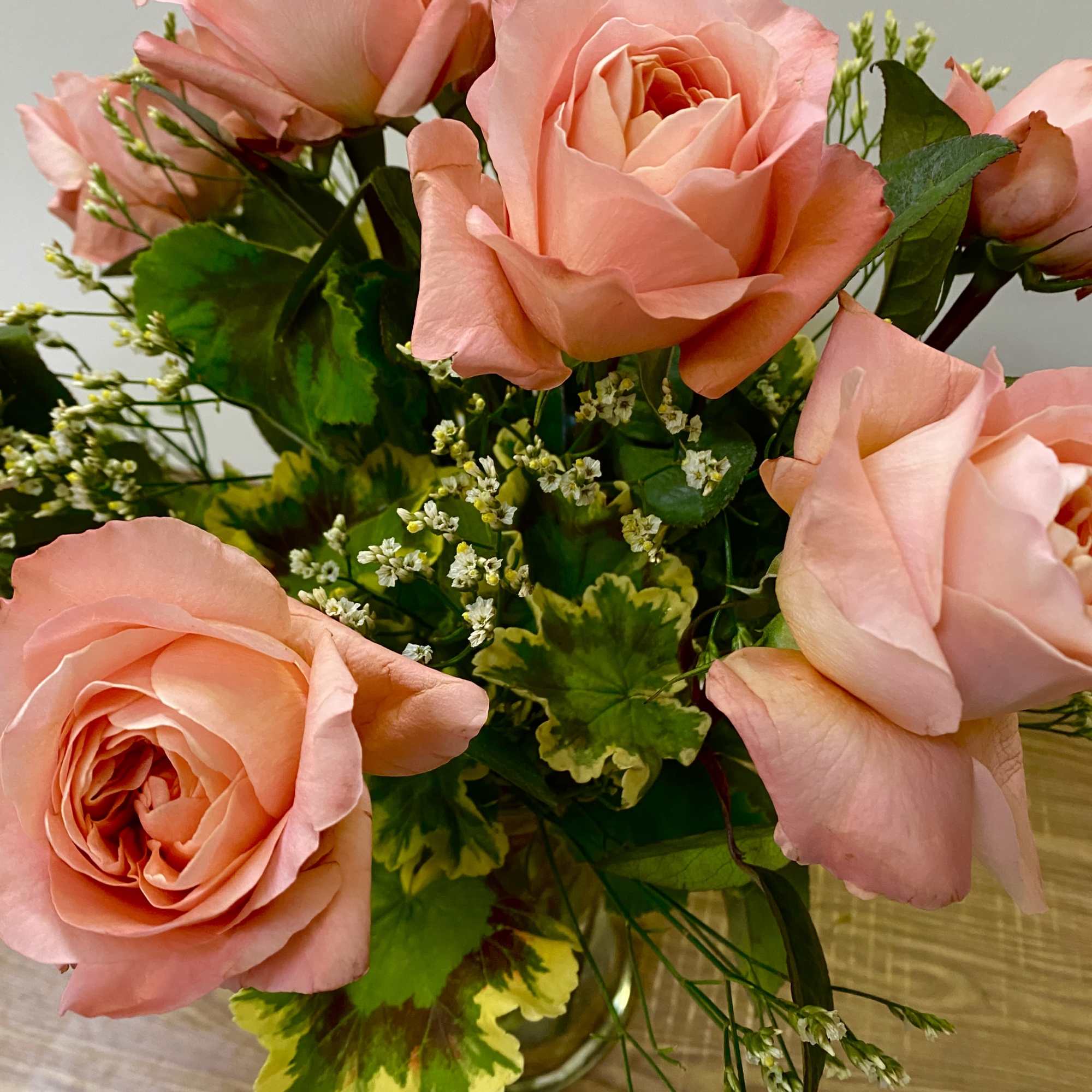 Bouquet of peach-pink roses in a glass vase