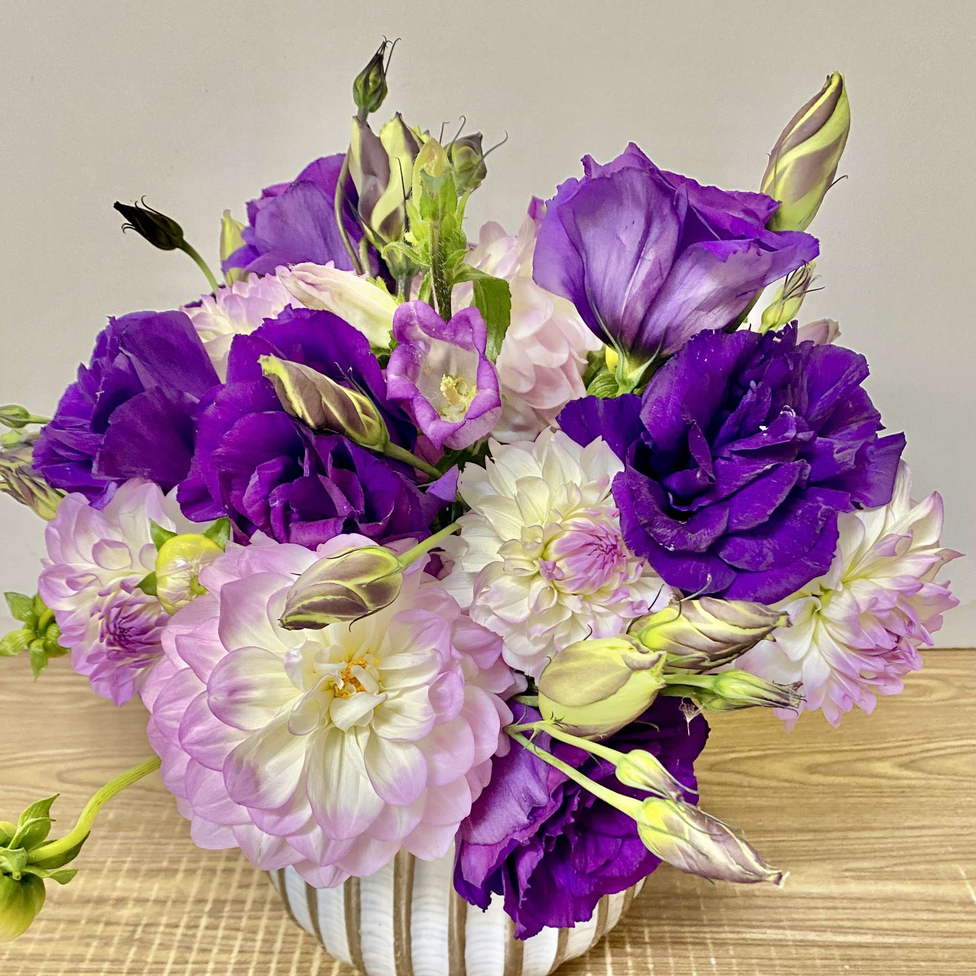 Purple and pink flowers arranged in a white vase