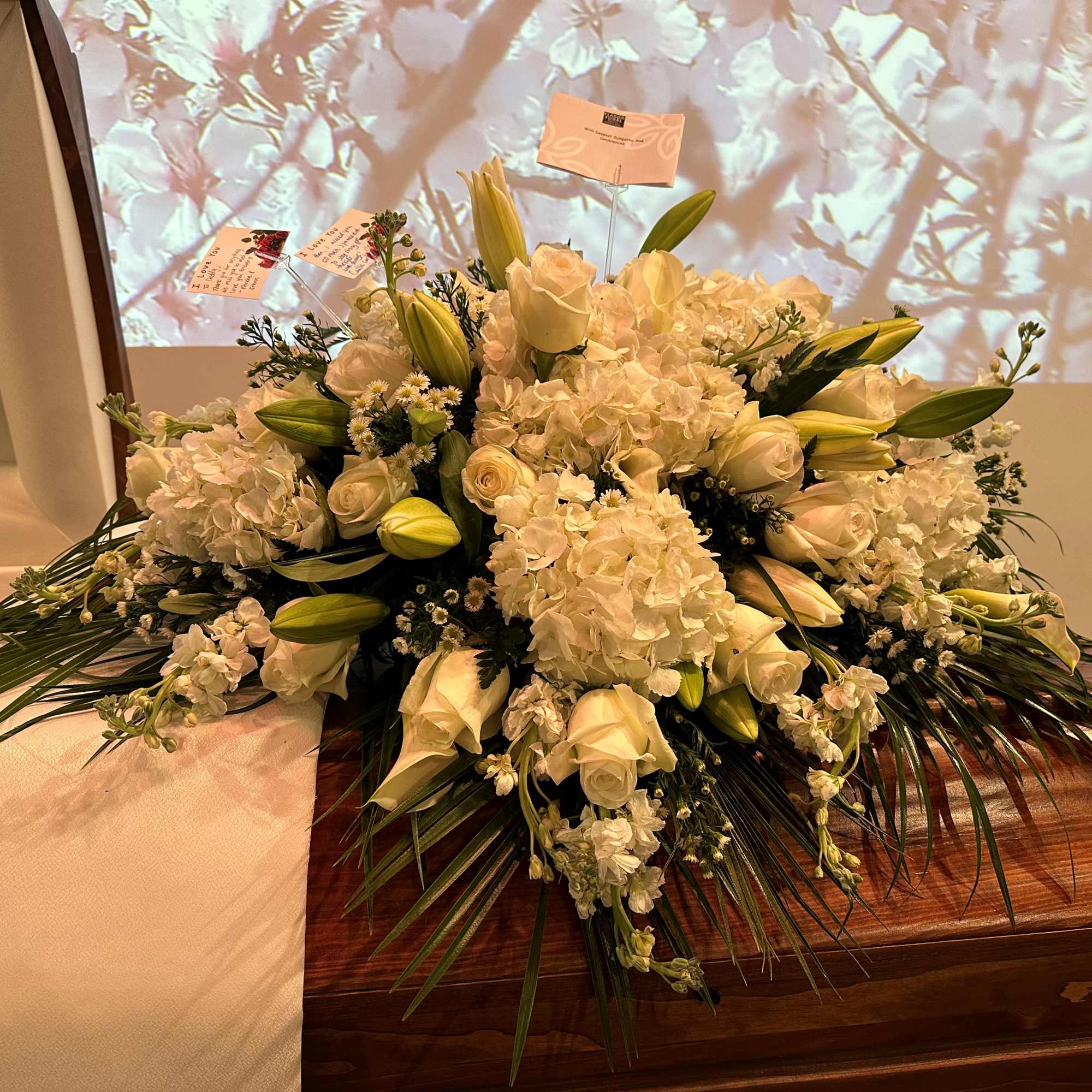 White floral casket spray with roses, lilies, and hydrangeas, photo 2 of 2