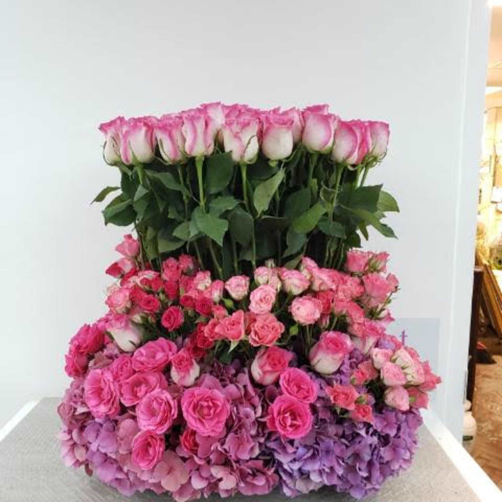 Large pink rose arrangement with hydrangeas on a table