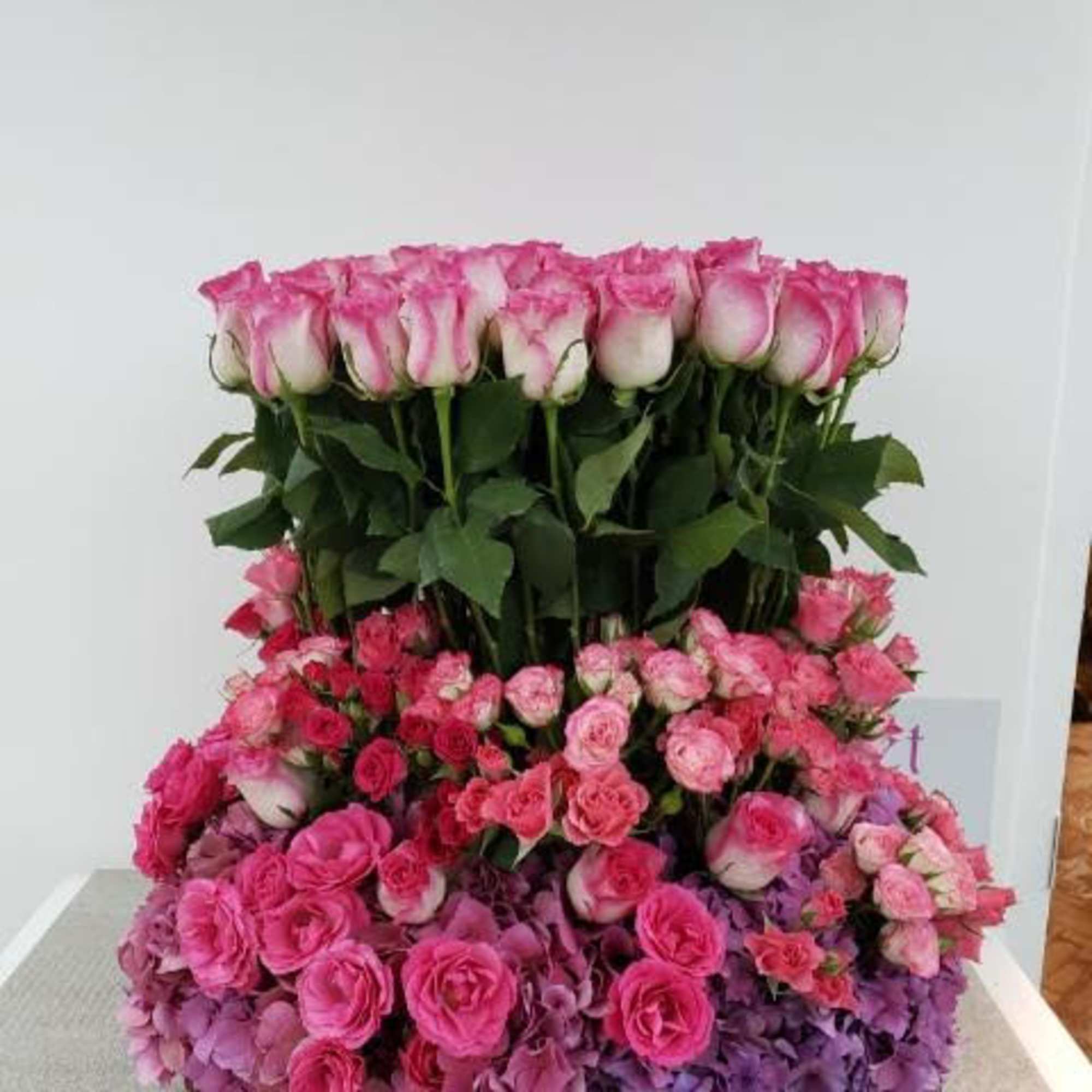 Tiered arrangement of pink roses and hydrangeas