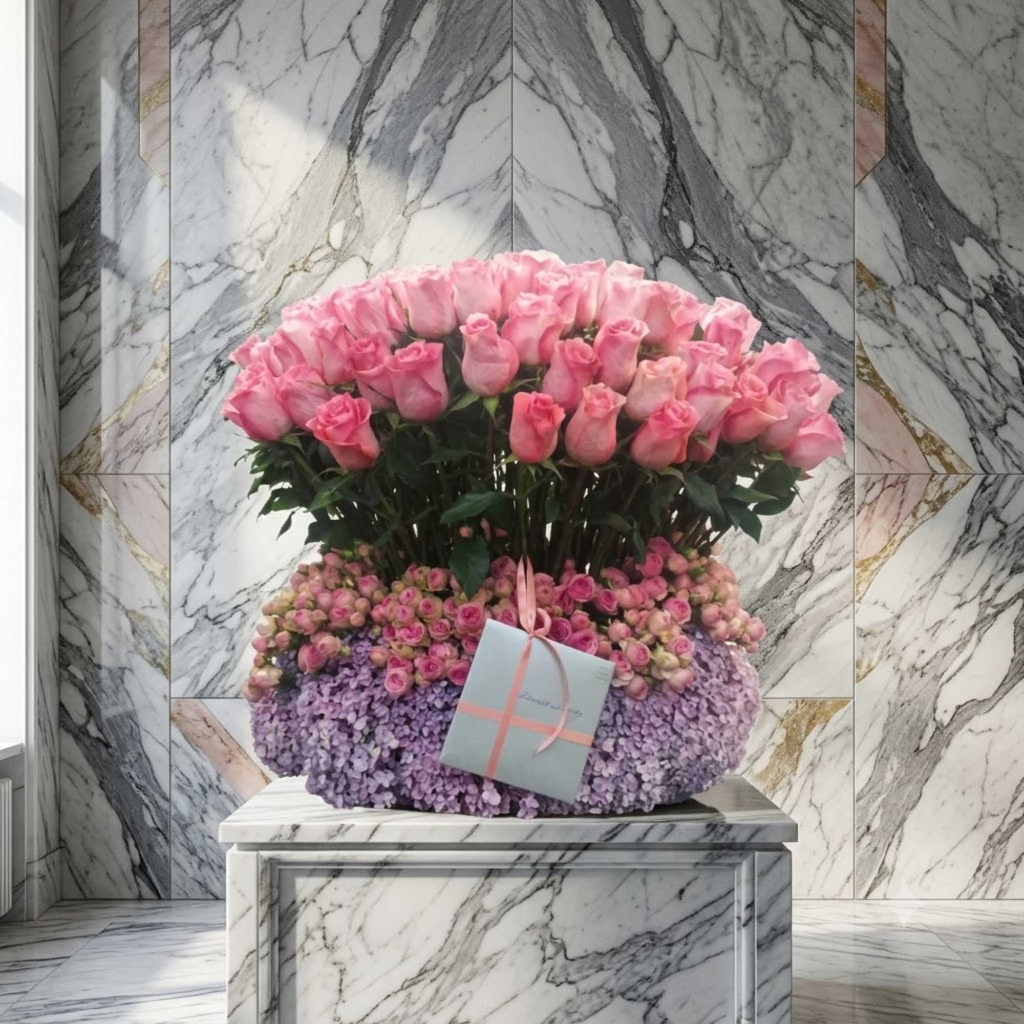 Large pink rose arrangement with a small gift card on a marble pedestal