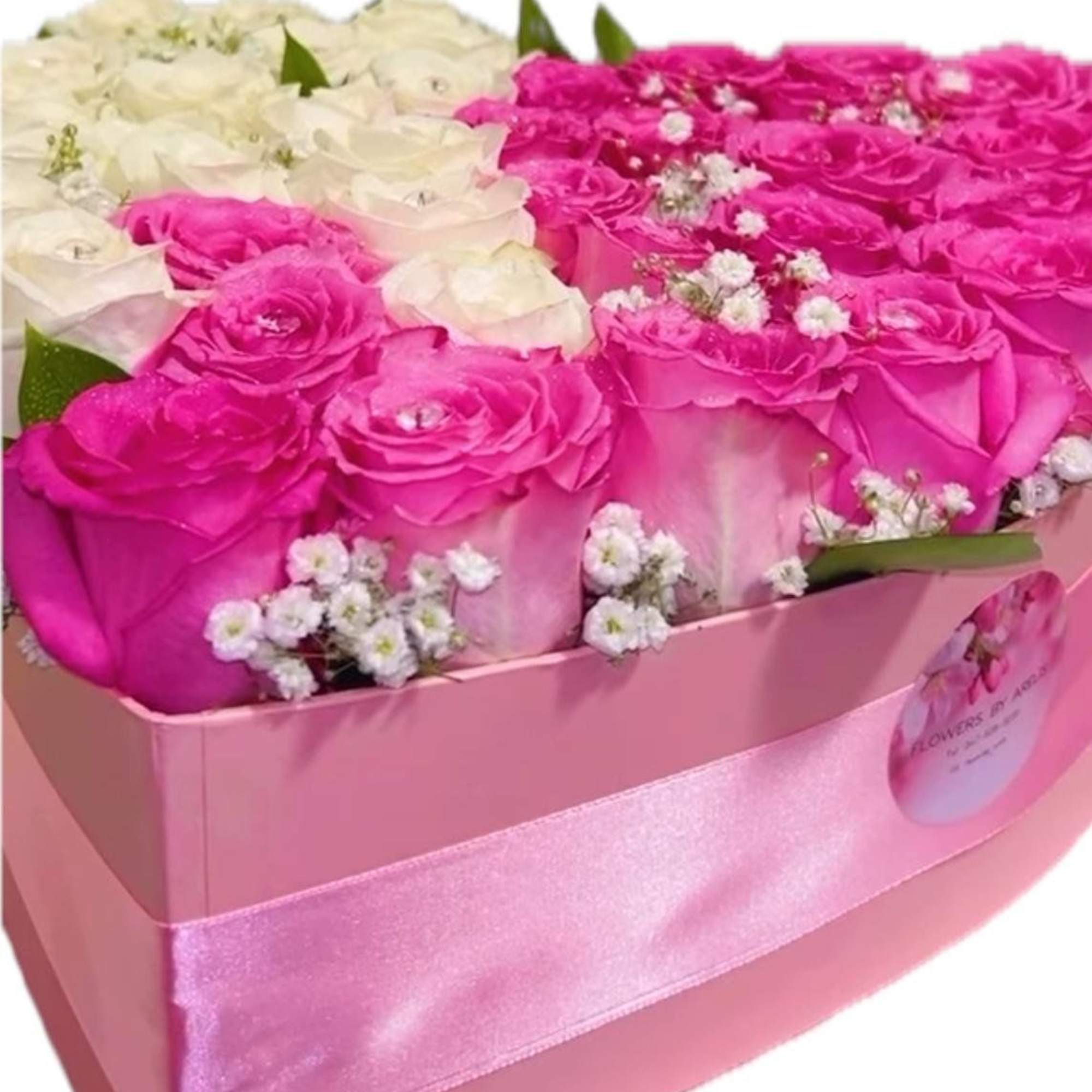 Pink and white roses arranged in a pink gift box with ribbon
