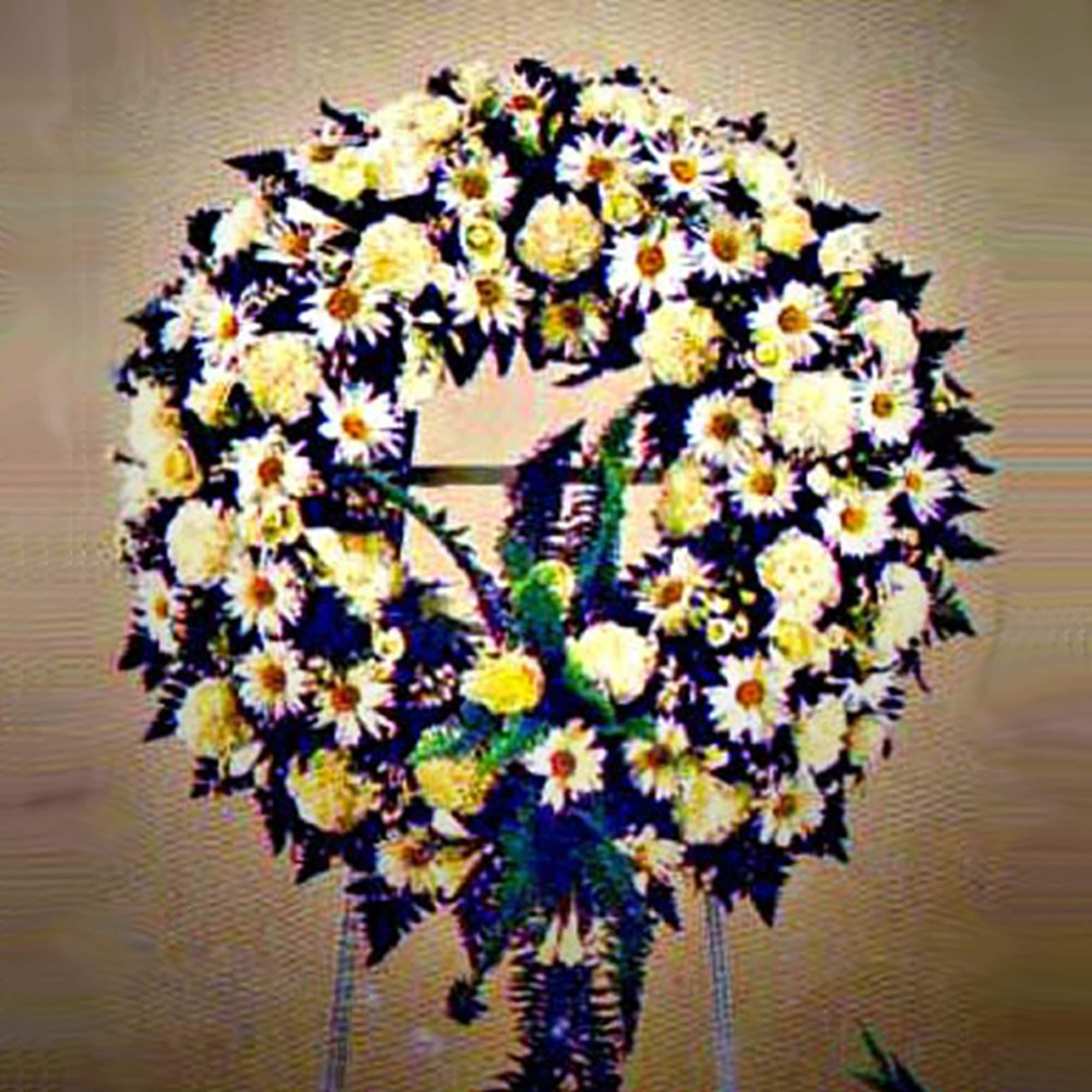Large white and yellow floral wreath on a standing easel