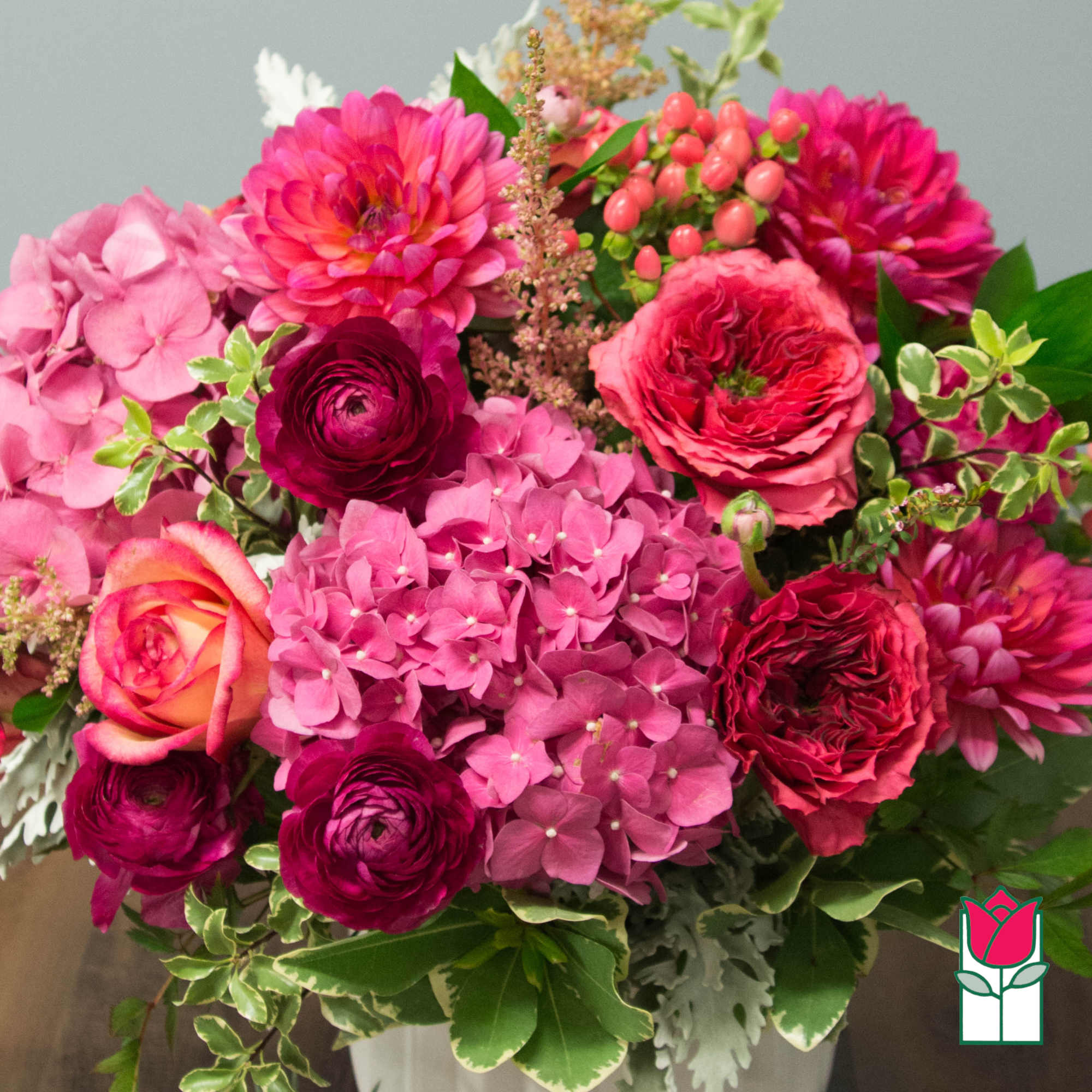 Pink and magenta bouquet with hydrangeas, roses, and ranunculus in a vase