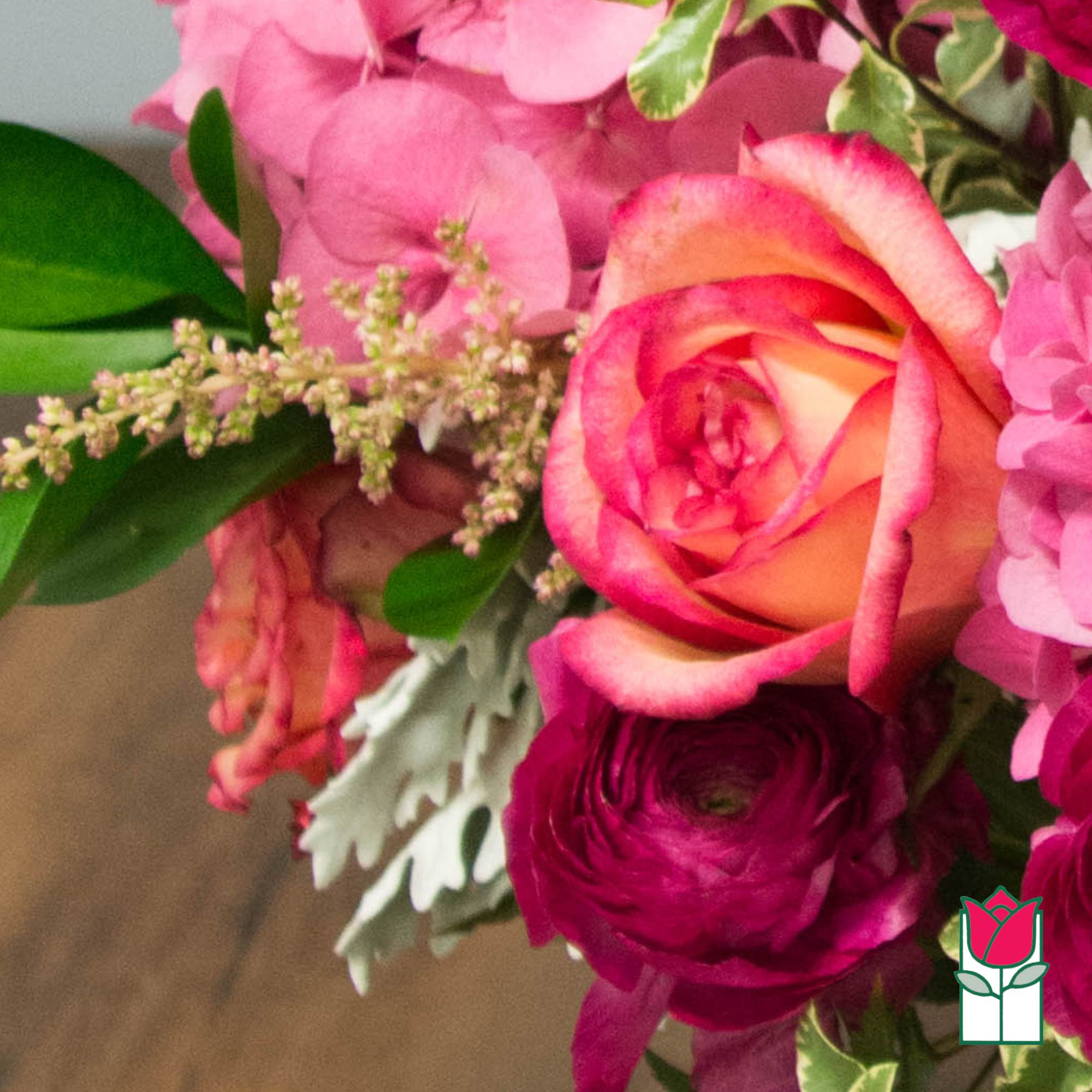 Pink and peach roses with magenta blooms in a bouquet