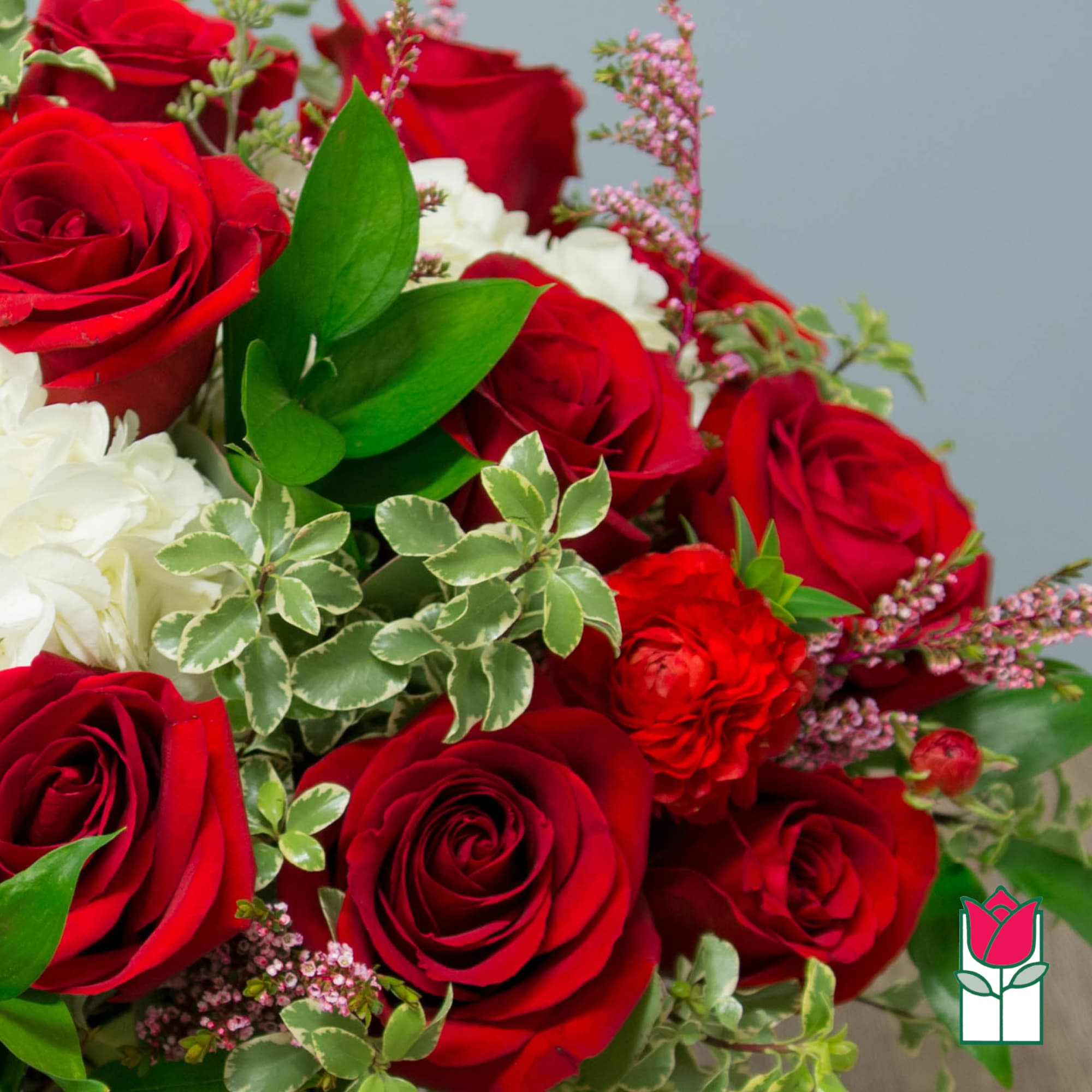 Bouquet of red and white roses with mixed greenery
