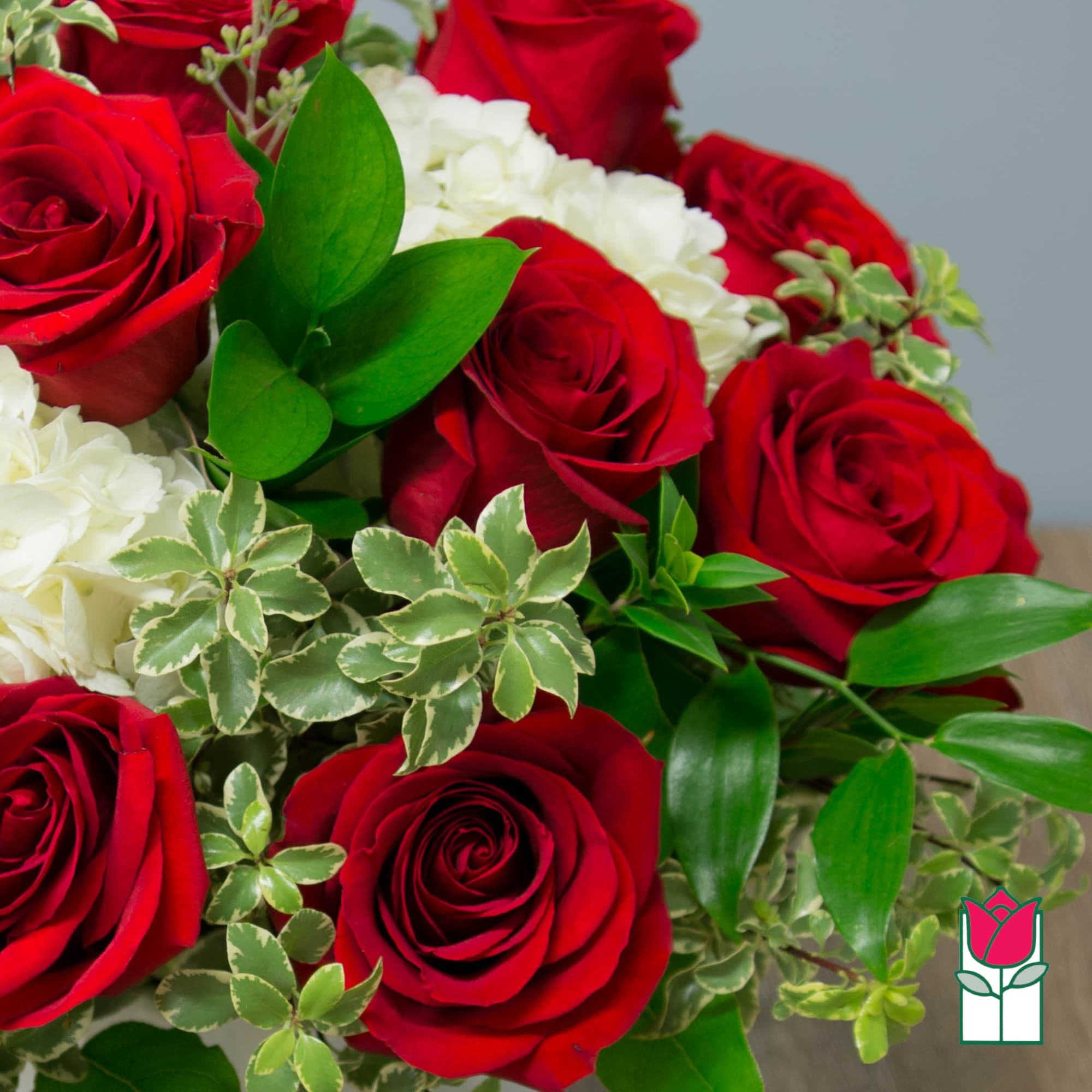 Bouquet of red roses and white flowers with green foliage