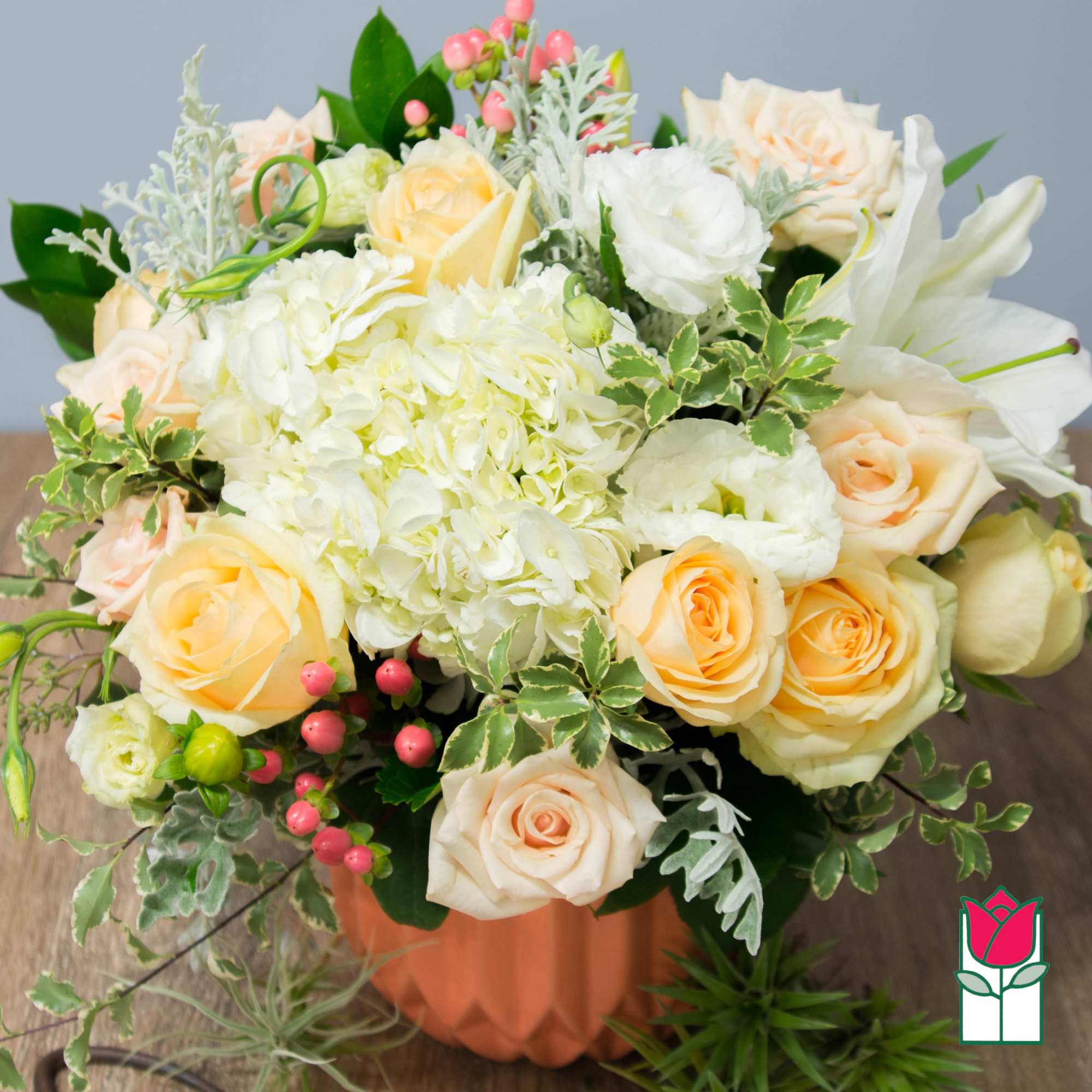 Peach roses and white hydrangeas in a peach vase