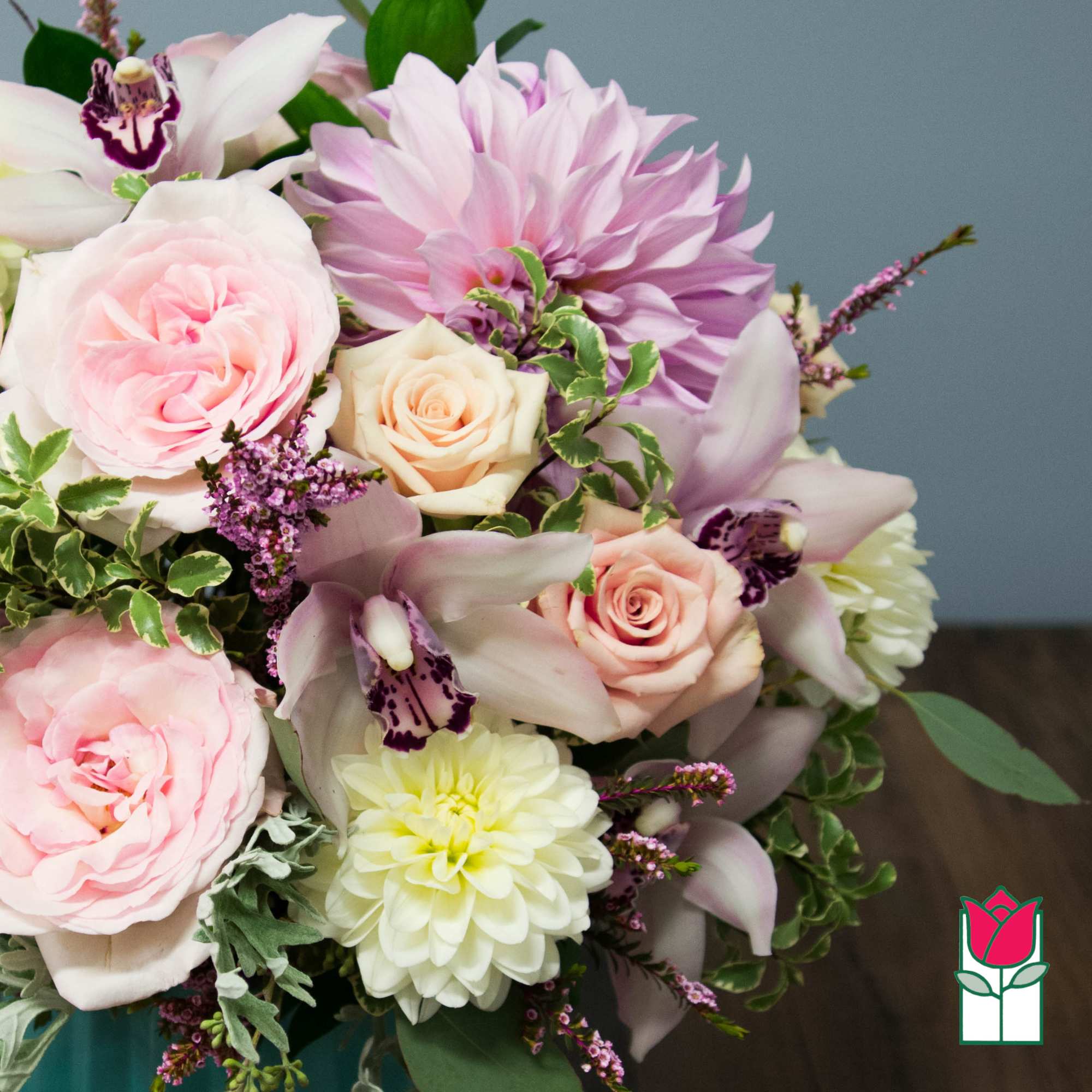 Bouquet of pink roses, orchids, and a lavender dahlia
