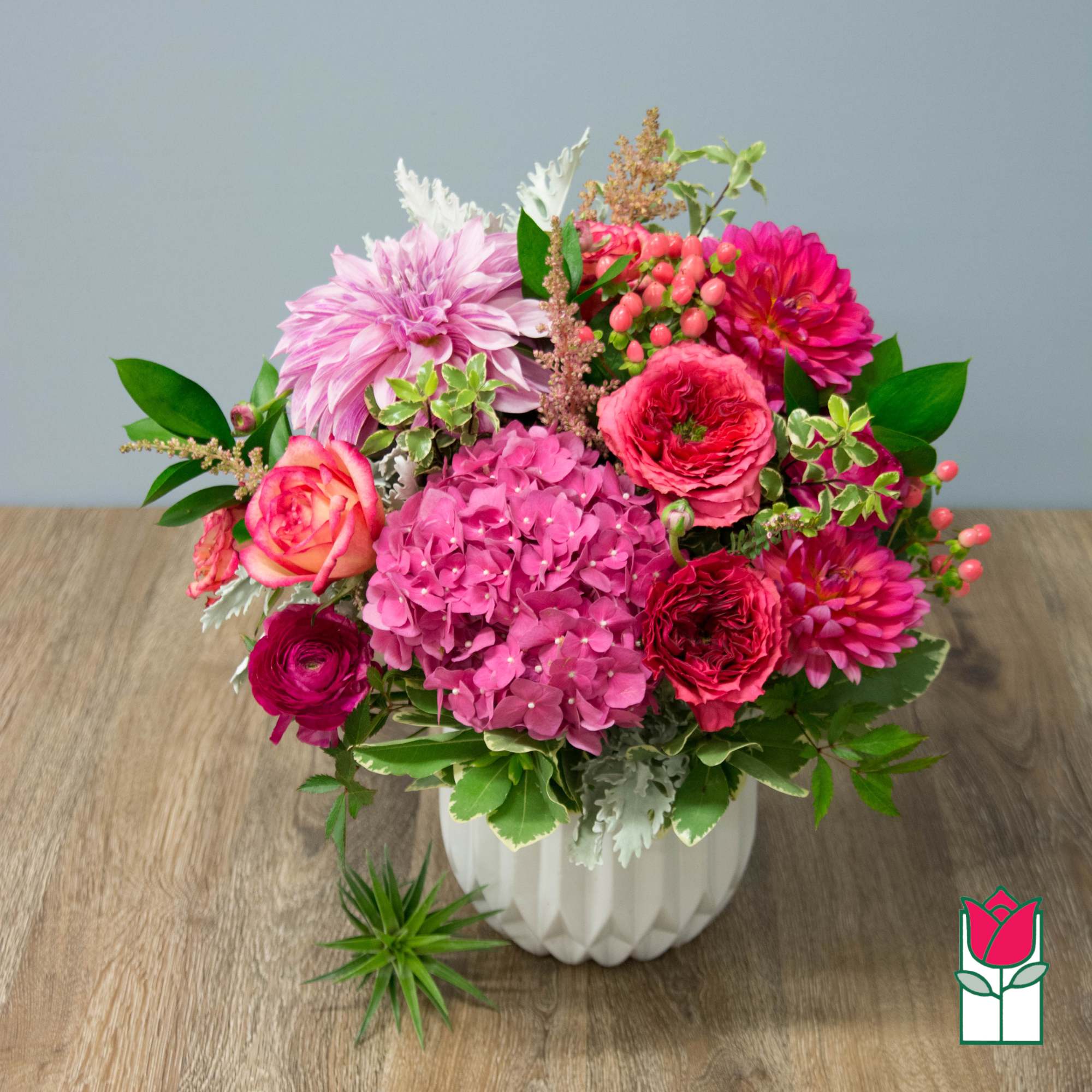 Pink and magenta mixed bouquet in a white vase