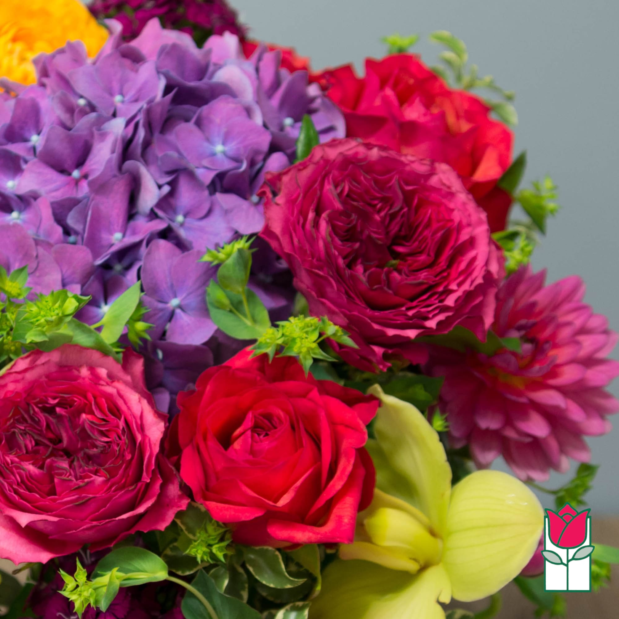Bouquet of purple hydrangea, red roses, and pink blooms