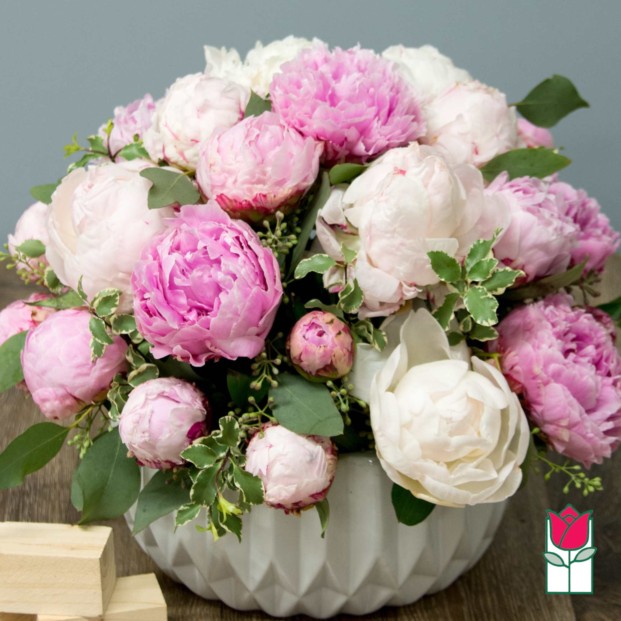 Pink and white peonies arranged in a white vase