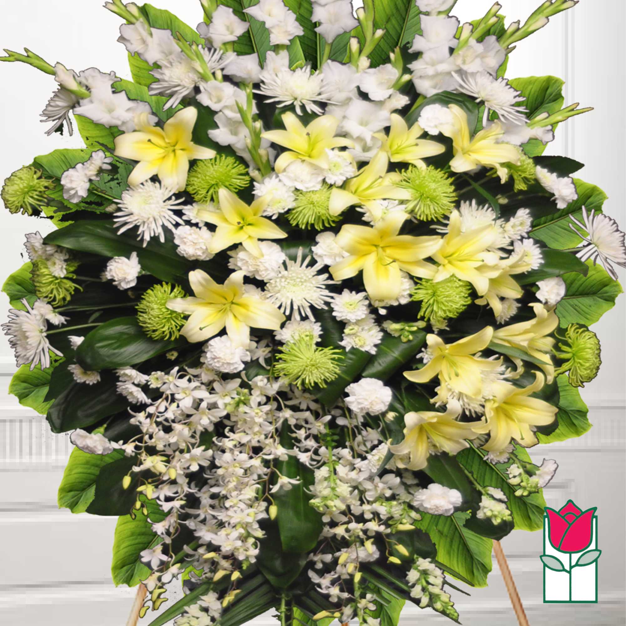Large standing floral spray with yellow lilies, white flowers, and green accents