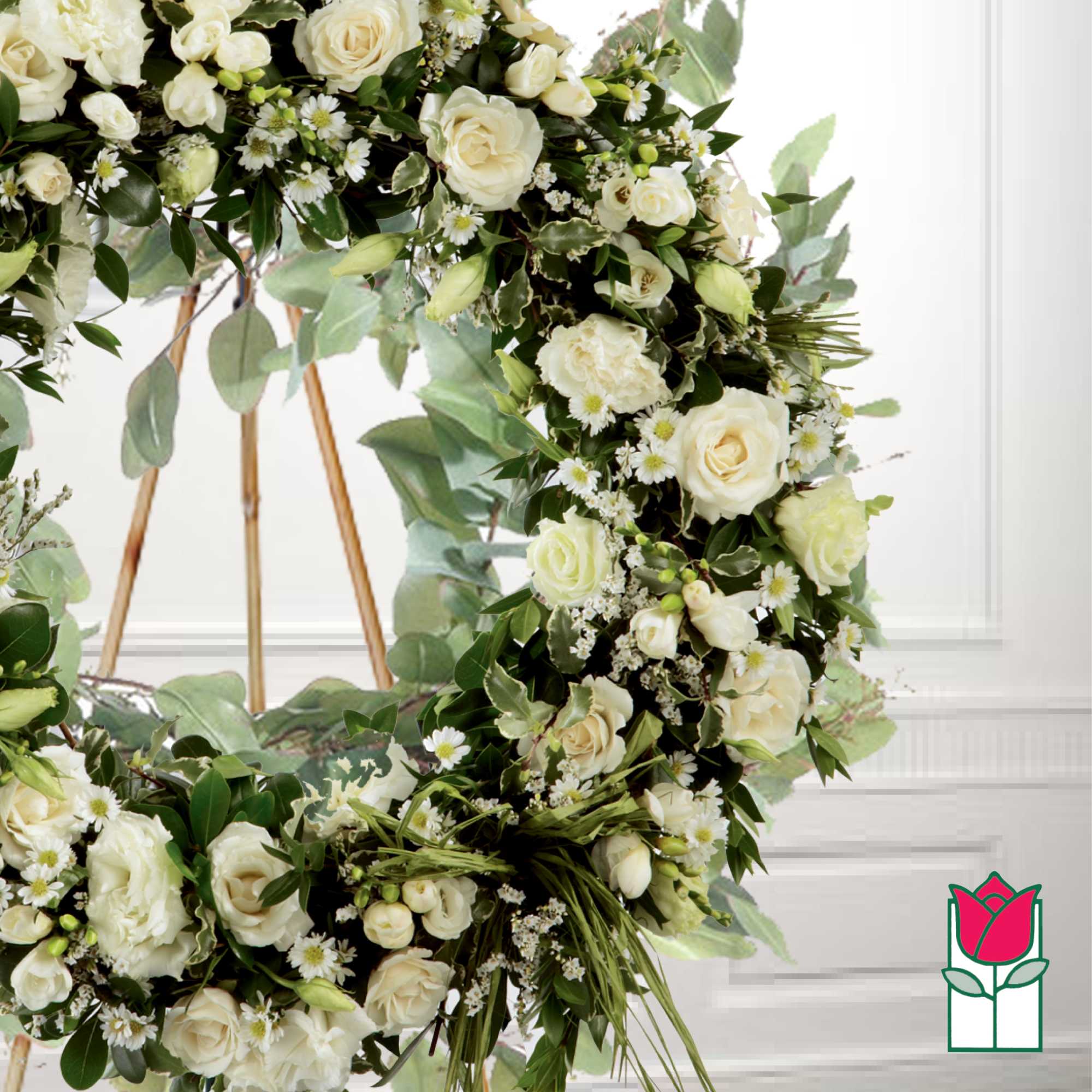 Cream rose floral wreath with small white daisies on a stand