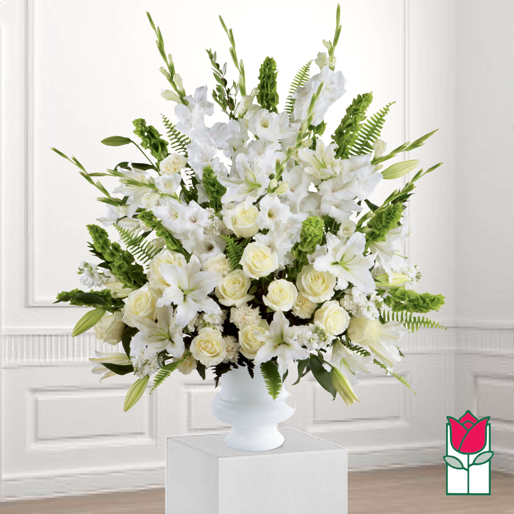 White floral arrangement in a white vase with green accents