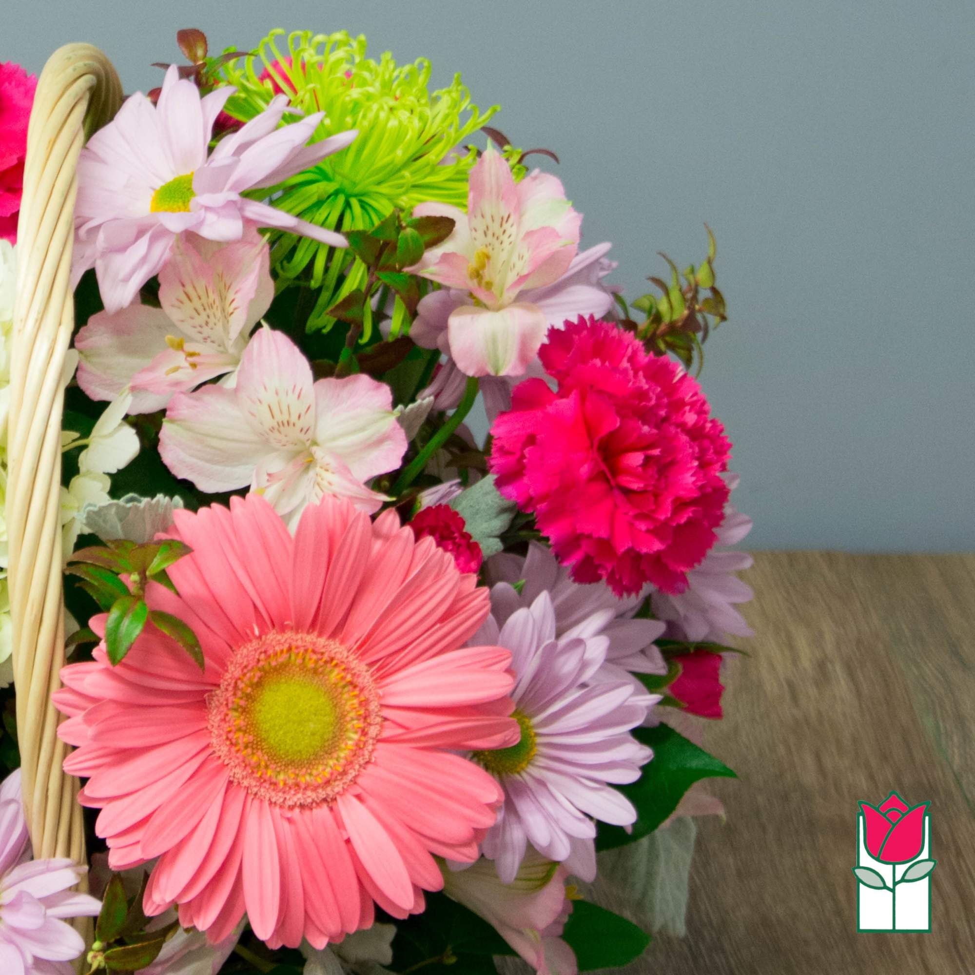 Basket of pink and lavender flowers with a bright pink carnation and gerbera daisy