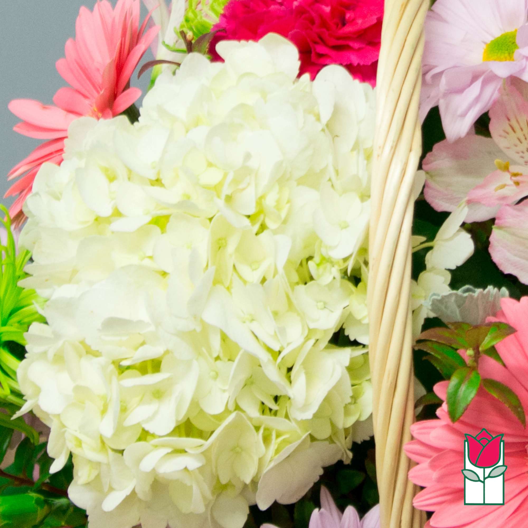 Basket of pastel flowers with a large white hydrangea cluster