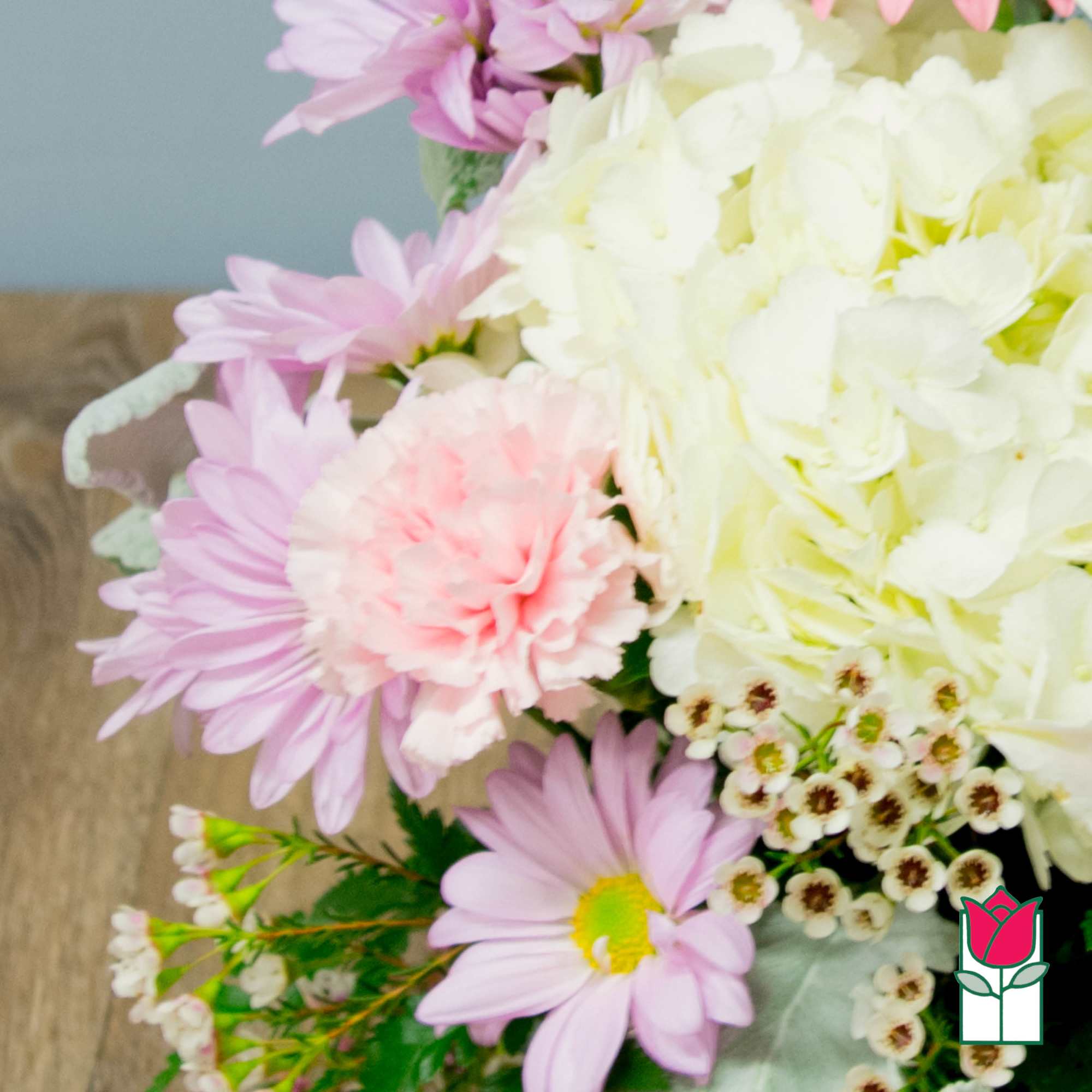 Bouquet of pink daisies, pale hydrangea, and a pink carnation