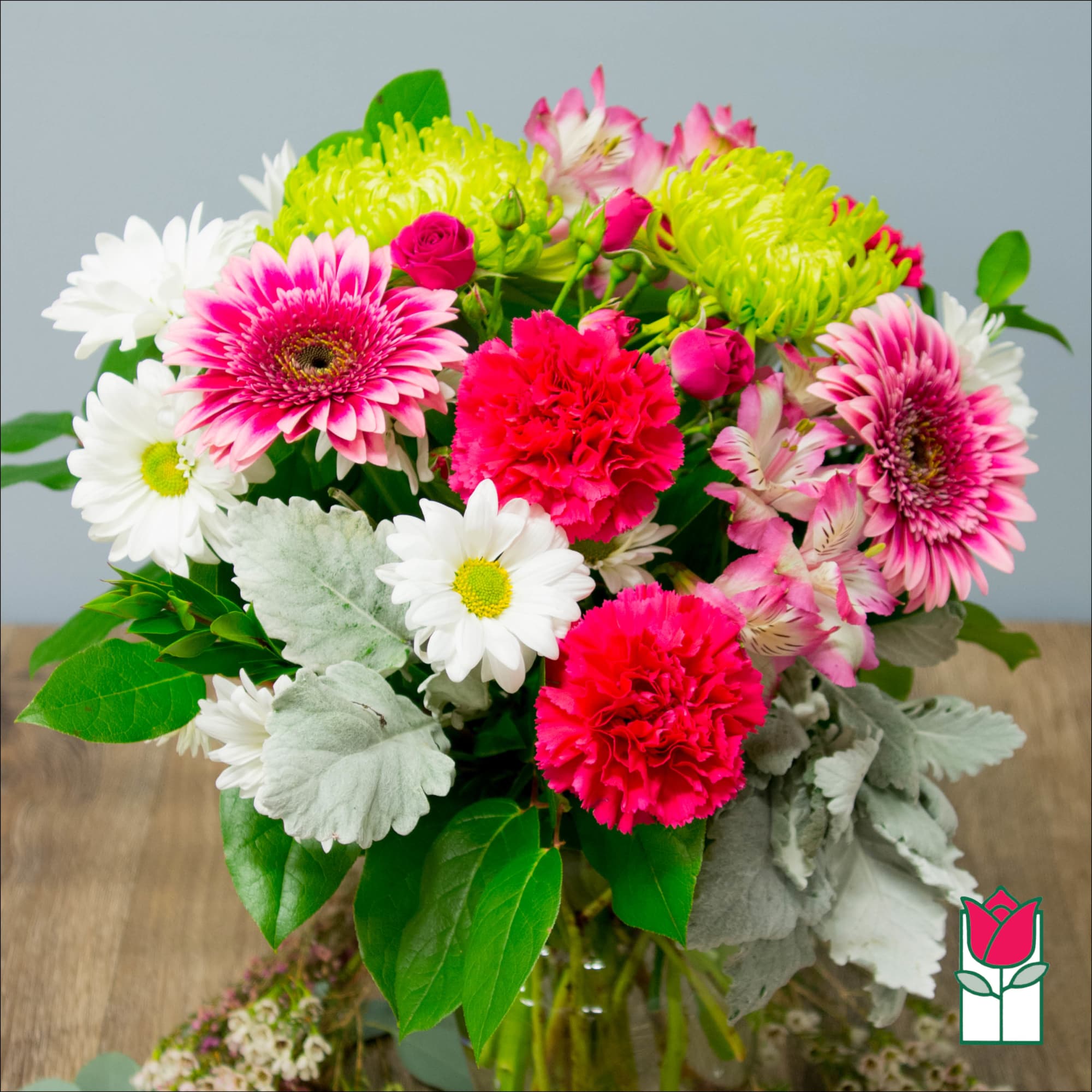 Pink and white mixed bouquet with daisies, carnations, and green mums in a vase