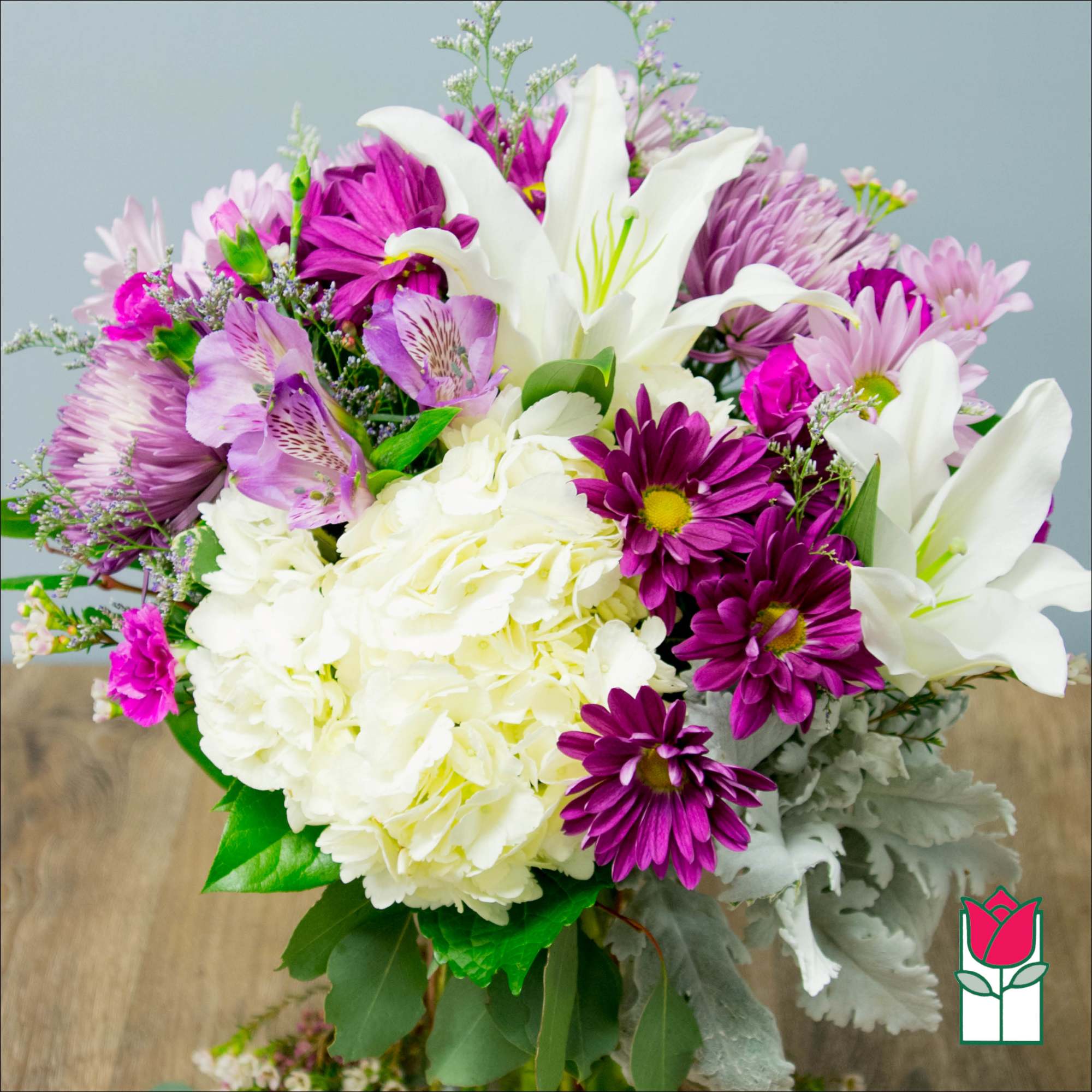 Bouquet of white lilies, purple daisies, and pale pink flowers