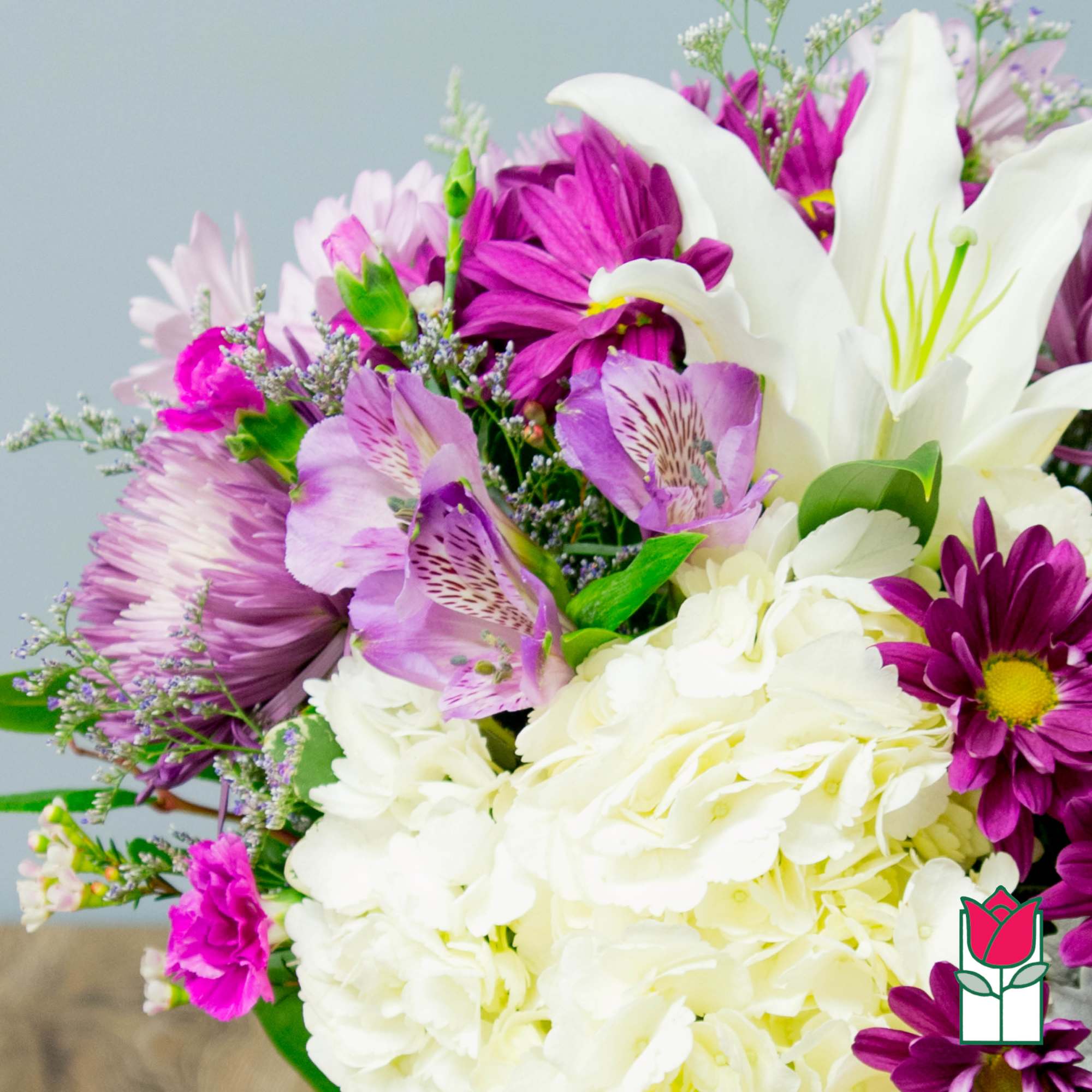 Bouquet of white lilies, purple daisies, and pink alstroemeria