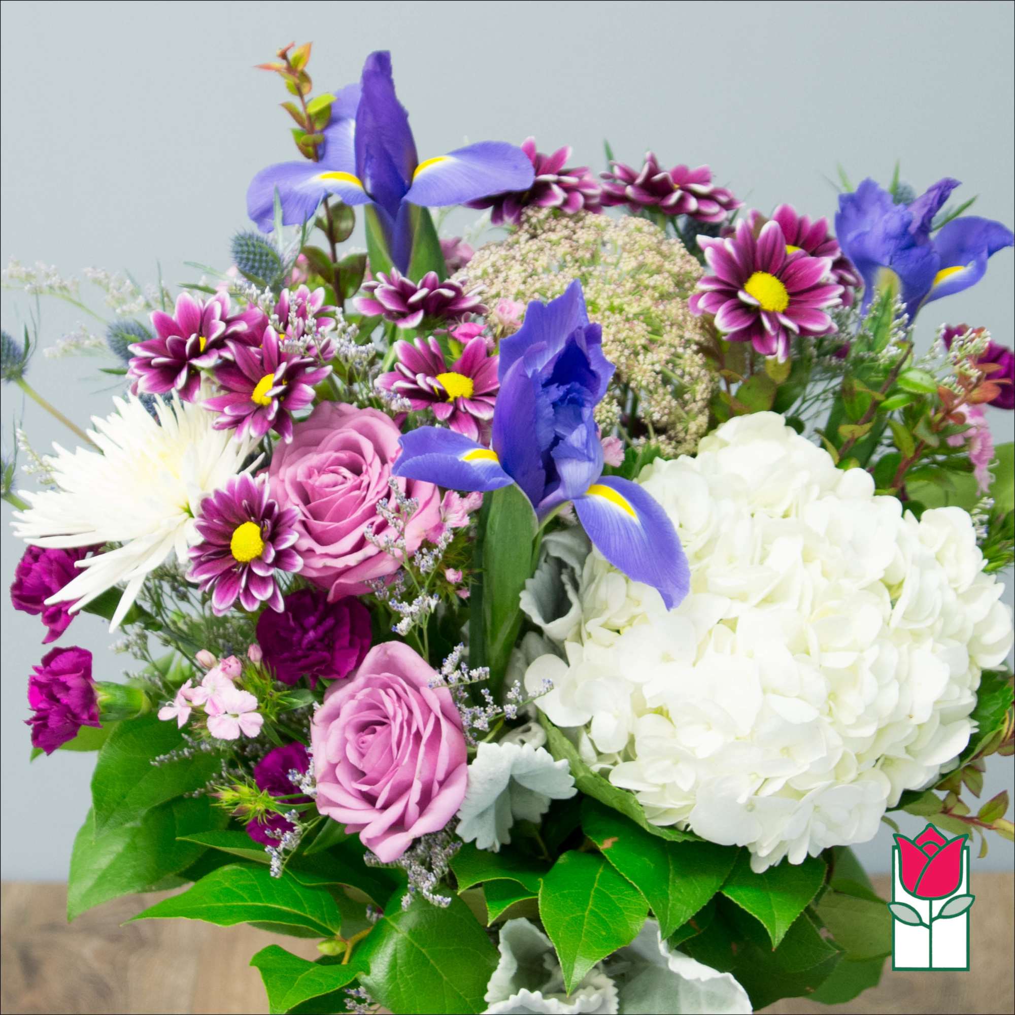 Bouquet of purple irises, pink roses, and white hydrangea