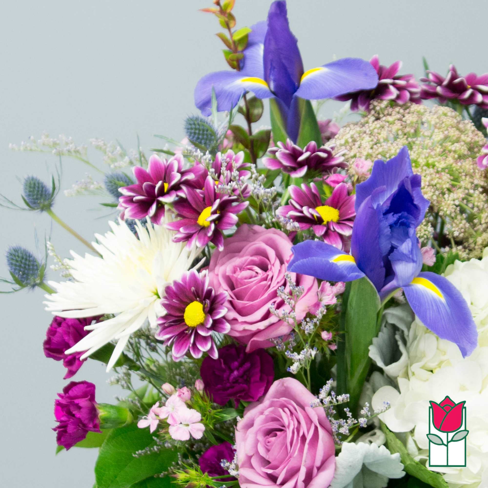 Mixed bouquet with purple irises, pink roses, and white blooms