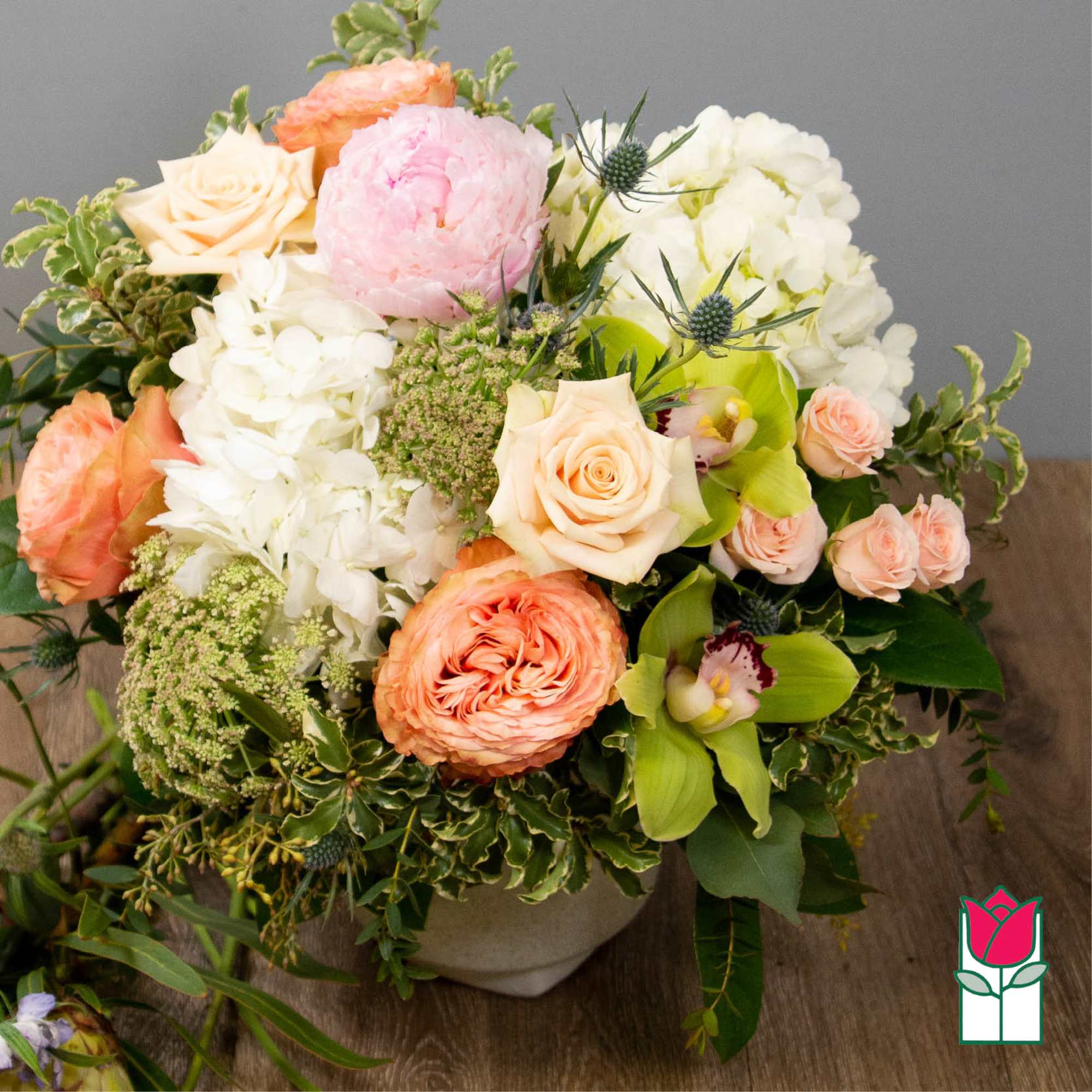 Mixed bouquet of peach, pink, and white flowers in a low vase, photo 3 of 5