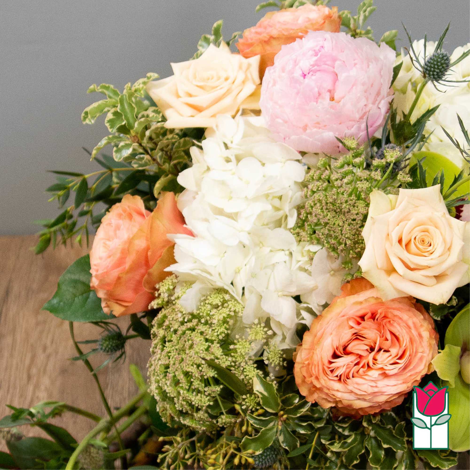 Bouquet of peach and pink roses with white hydrangea and greenery