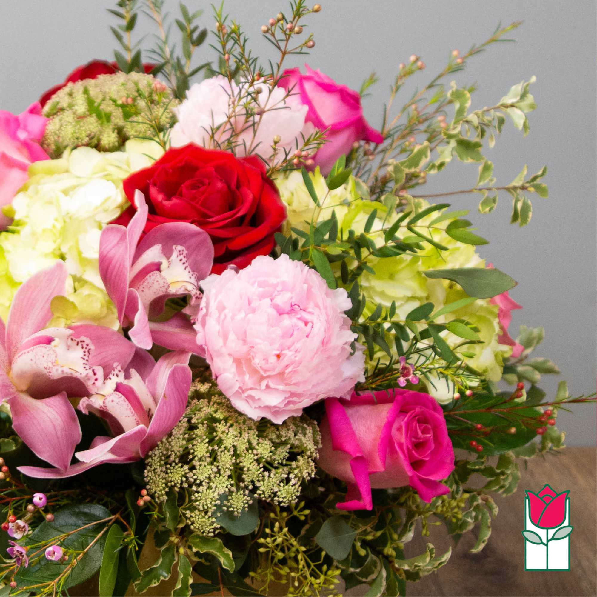 Bouquet of pink and red roses with orchids and a pale pink bloom