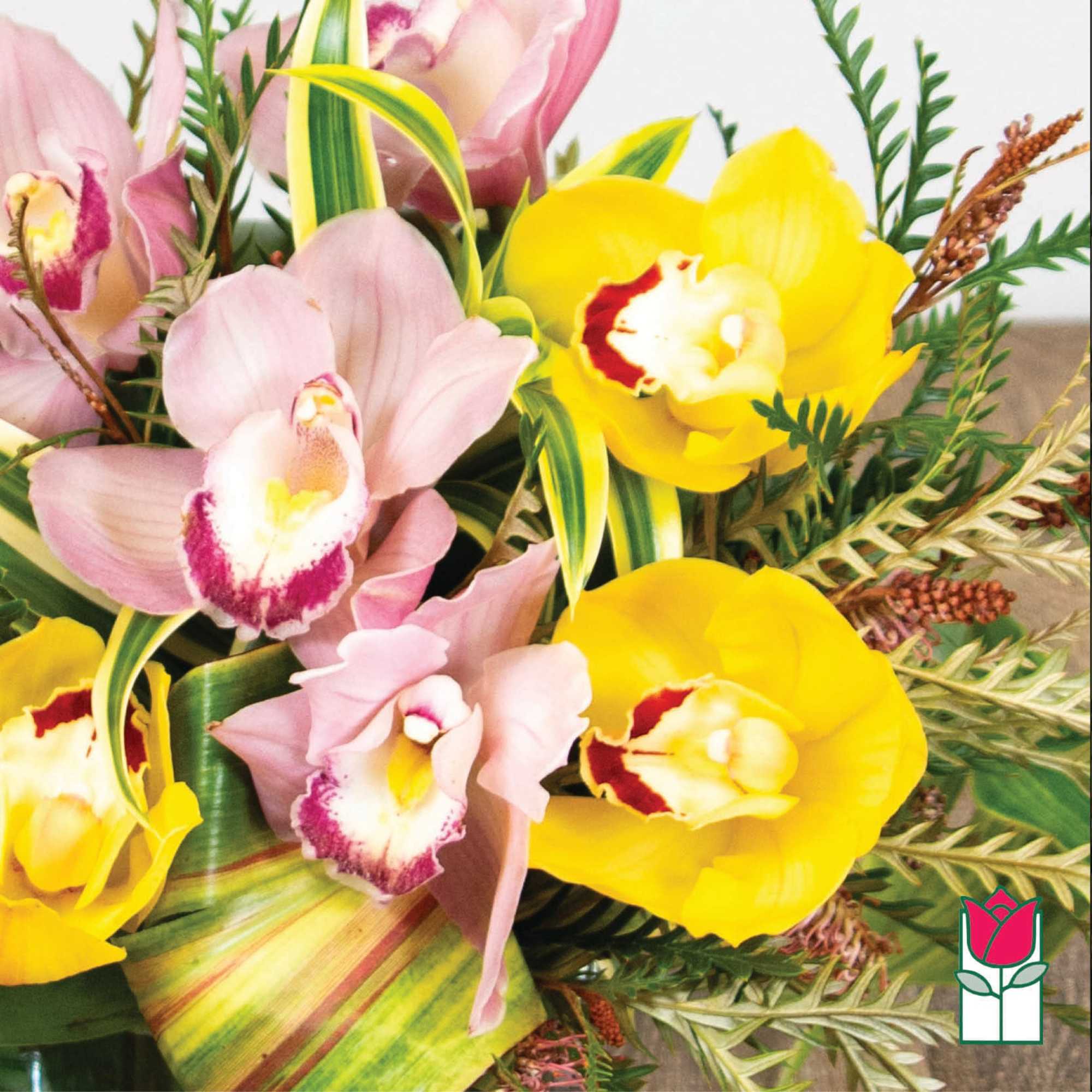 Bouquet of pink and yellow orchids with mixed greenery