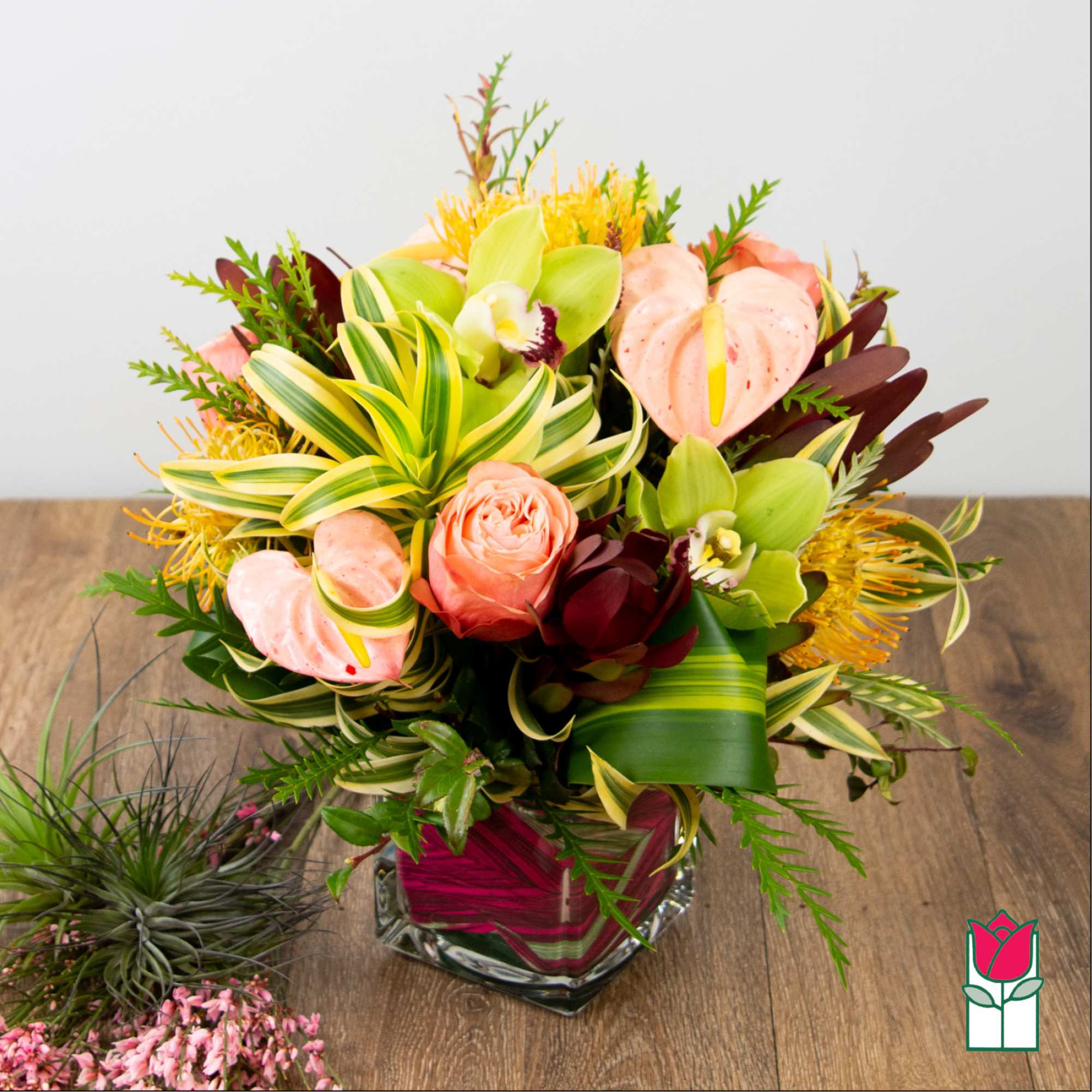 Tropical bouquet in a glass vase with pink and green blooms