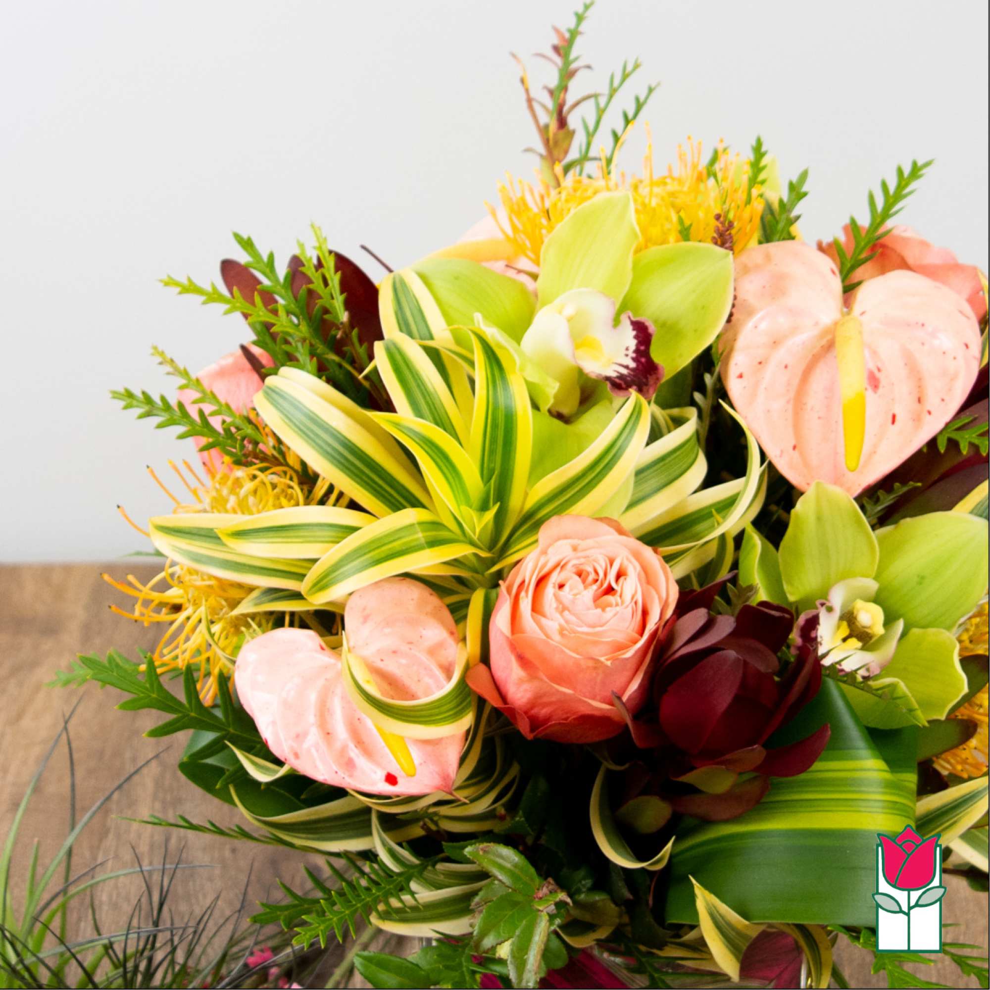 Tropical bouquet with pink anthuriums, orchids, and a peach rose