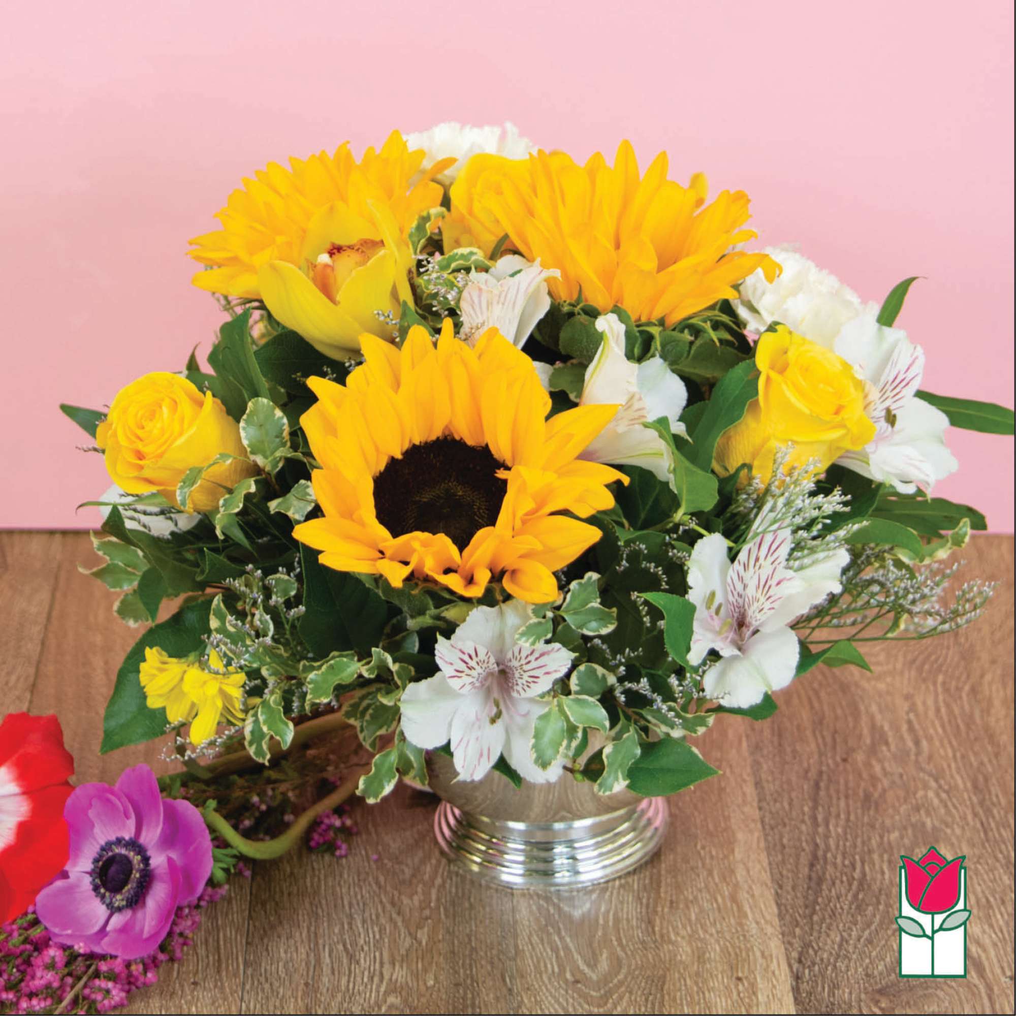 Bouquet of yellow sunflowers and white flowers in a silver vase