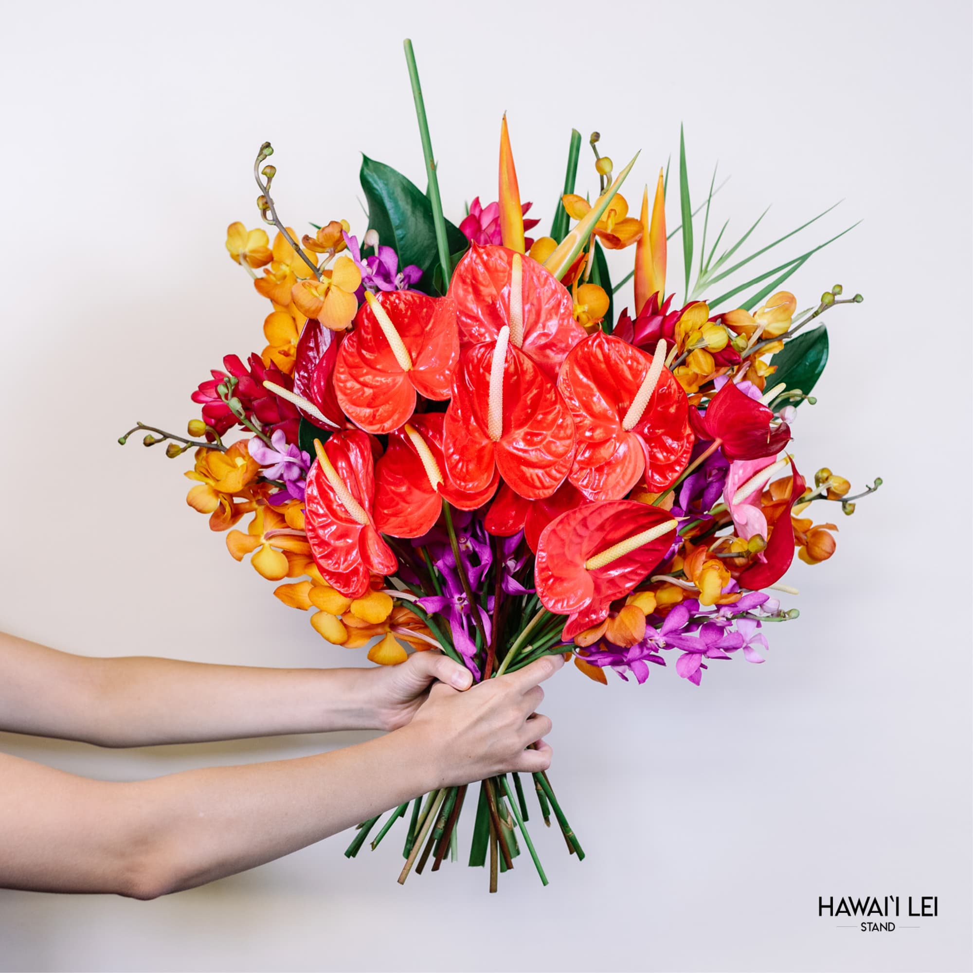 Tropical bouquet with red anthuriums and orange orchids